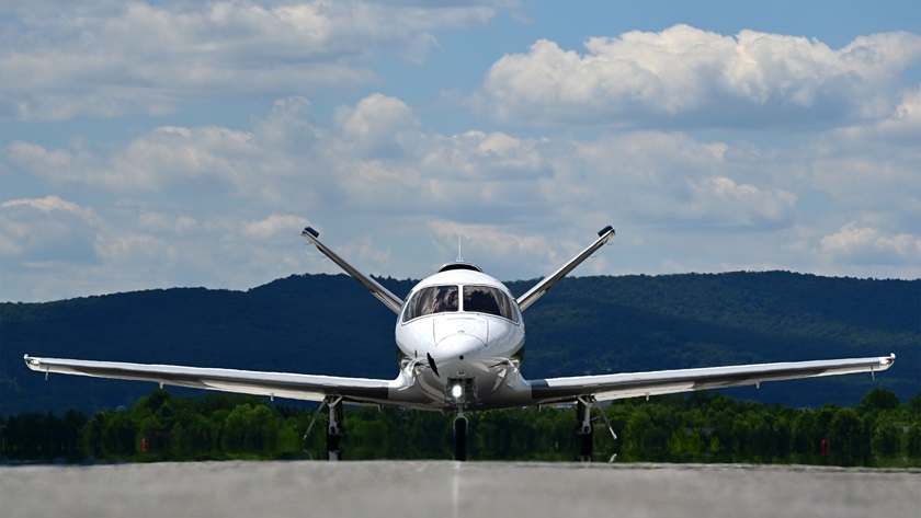 A Cirrus Vision Jet G2+ is framed by mountains near the Runway 12 threshold at Frederick Municipal Airport, June 23, 2021. Photo by David Tulis.