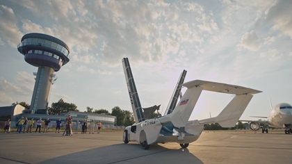 Invited media watch the AirCar transform (in 2 minutes and 15 seconds) from aircraft to automobile by folding the wings. Photo courtesy of Klein Vision.