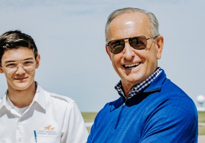 High school senior Aidan Nacke, shown with West Michigan Aviation Academy founder Dick DeVos, was the 100th student to earn a private pilot certificate. Photo courtesy of West Michigan Aviation Academy.