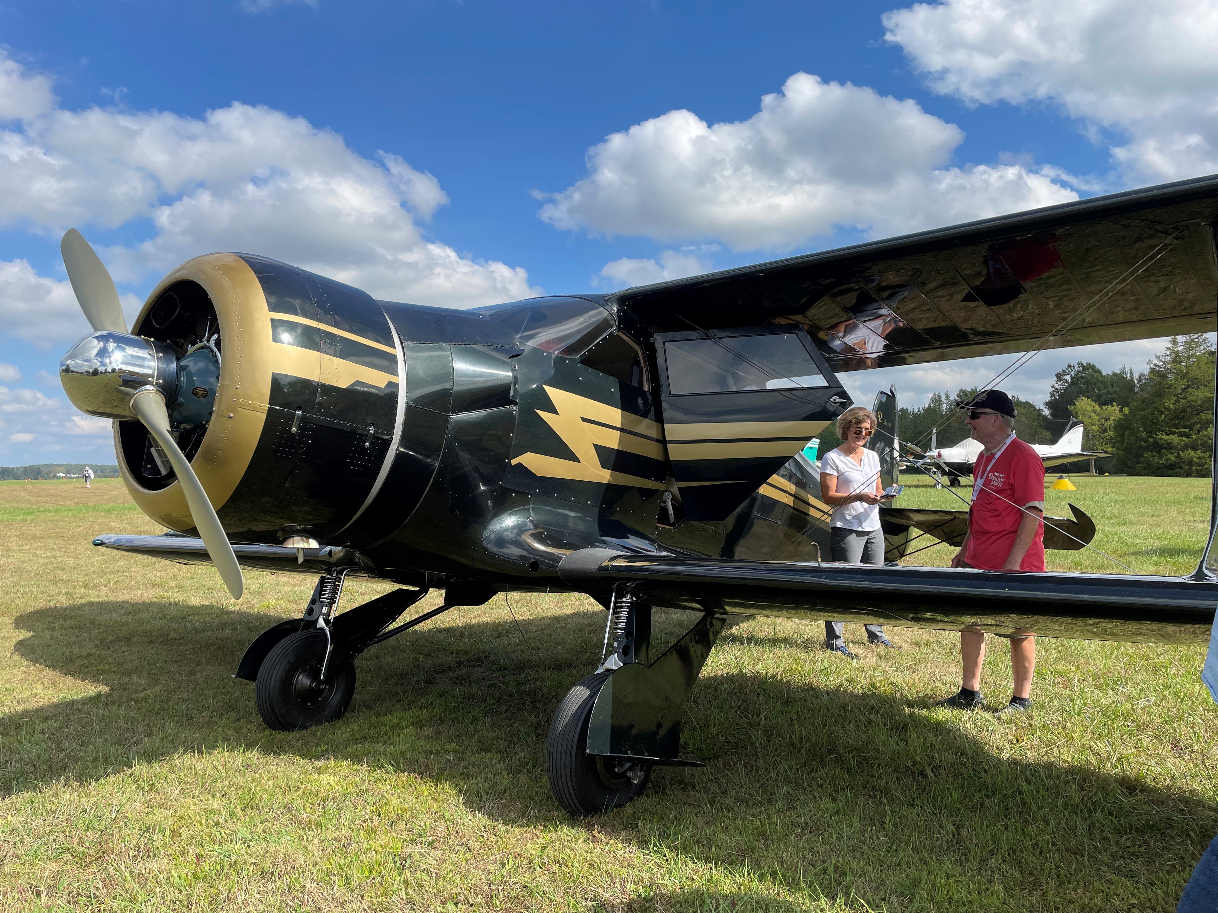Attendees gather around a gold-and-black Beechcraft Staggerwing. Photo courtesy of Madison Murray.