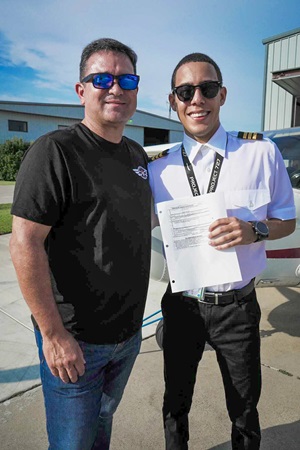 Christian Santiago stands beside René Asencio after receiving his commercial certificate. Photo courtesy of Cristian Santiago.
