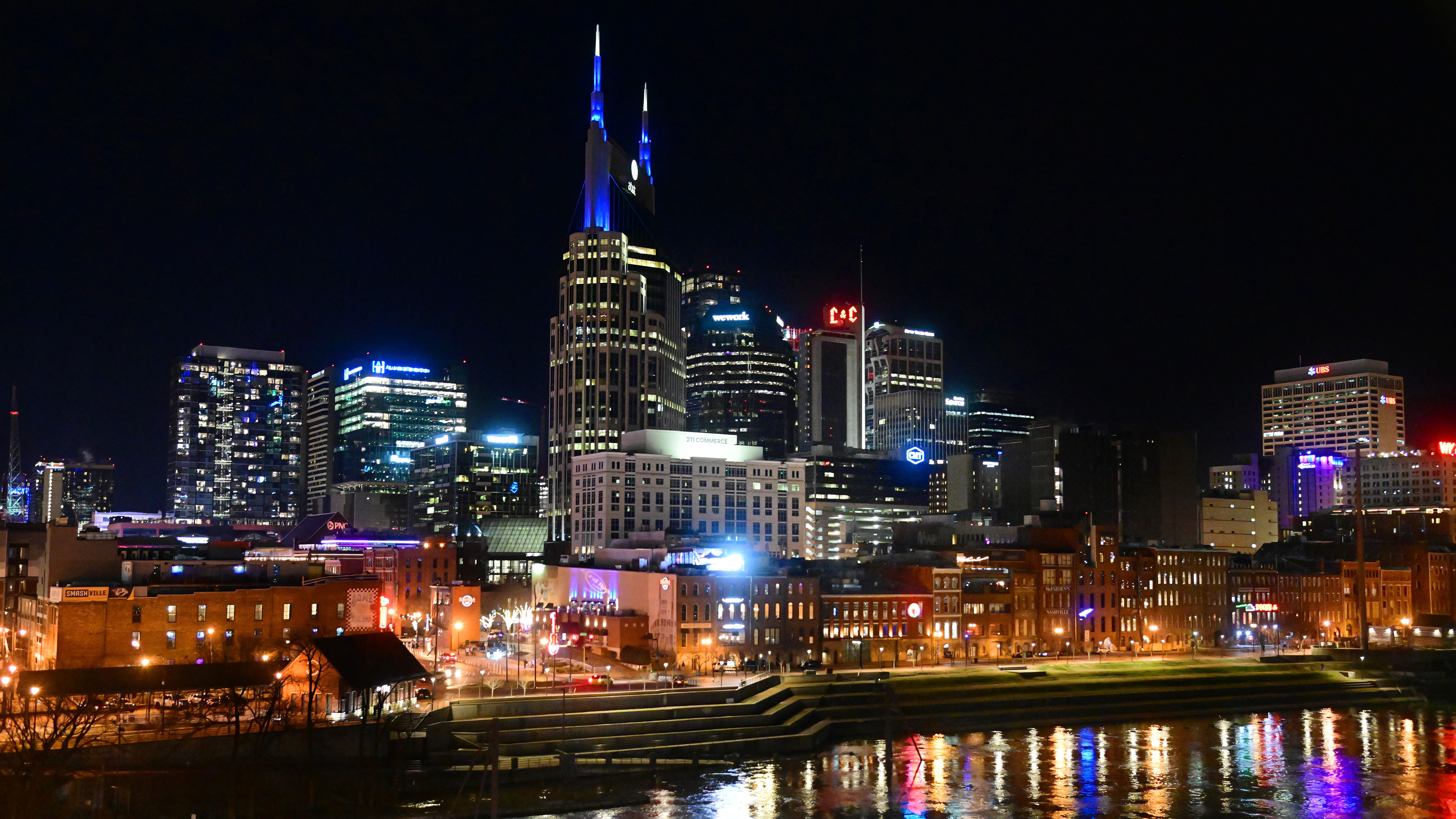 Lower Broadway is aglow adjacent to the Cumberland River that runs through Nashville after an NFL playoff game between the Tennessee Titans and the Cincinnati Bengals in January 2022. Photo by David Tulis.