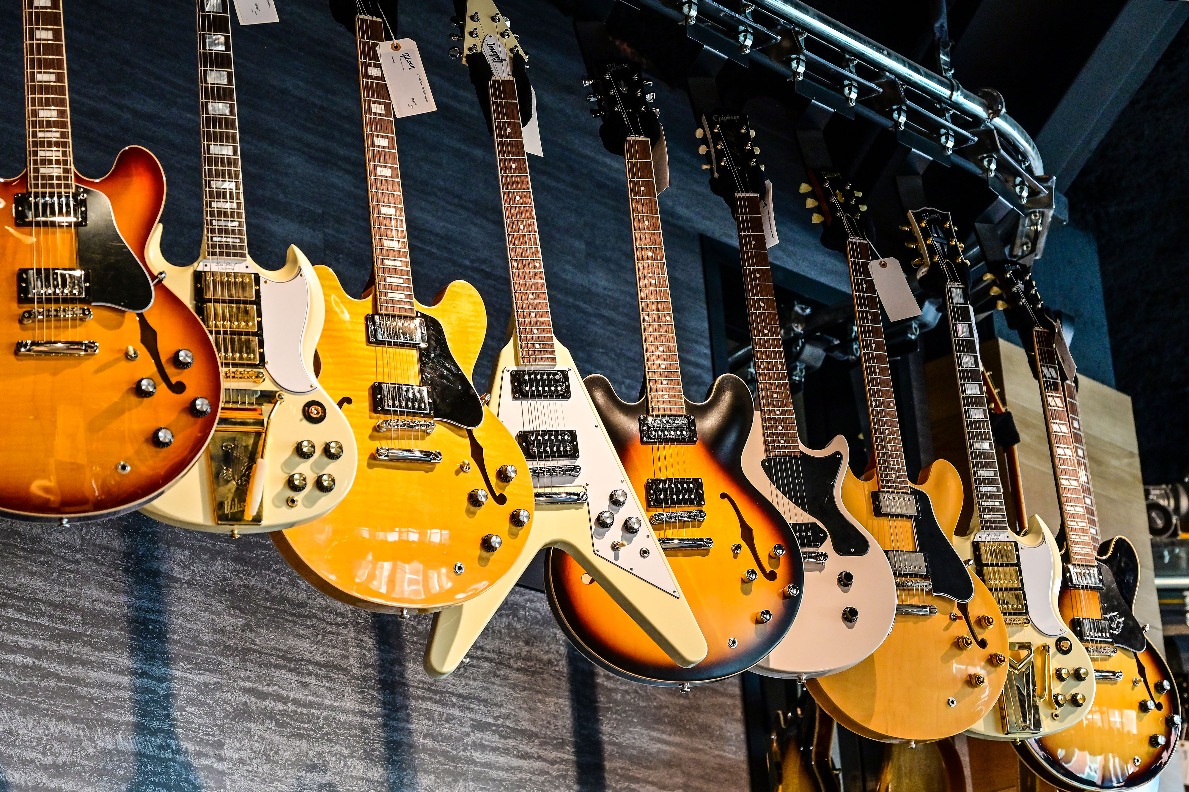 Rows of Gibson electric guitars including Les Pauls, Flying Vs, SGs, and ES-335s rotate along the ceiling at the Gibson Garage, a music store and guitar archive. Photo by David Tulis.