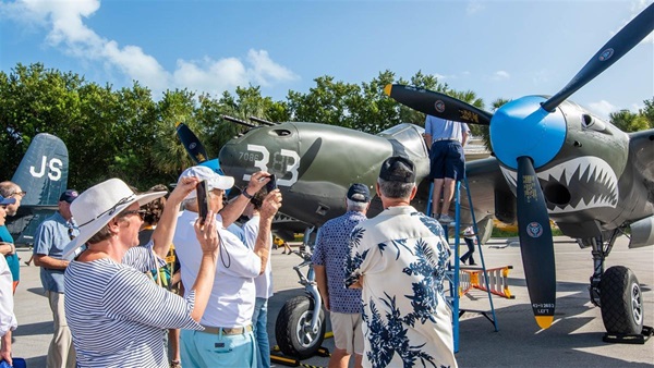 Attendees admire the Lockheed P-38 'White 33’ at Ocean Reef Club’s Vintage Weekend in Key Largo, Florida. Photo by Niki Britton.