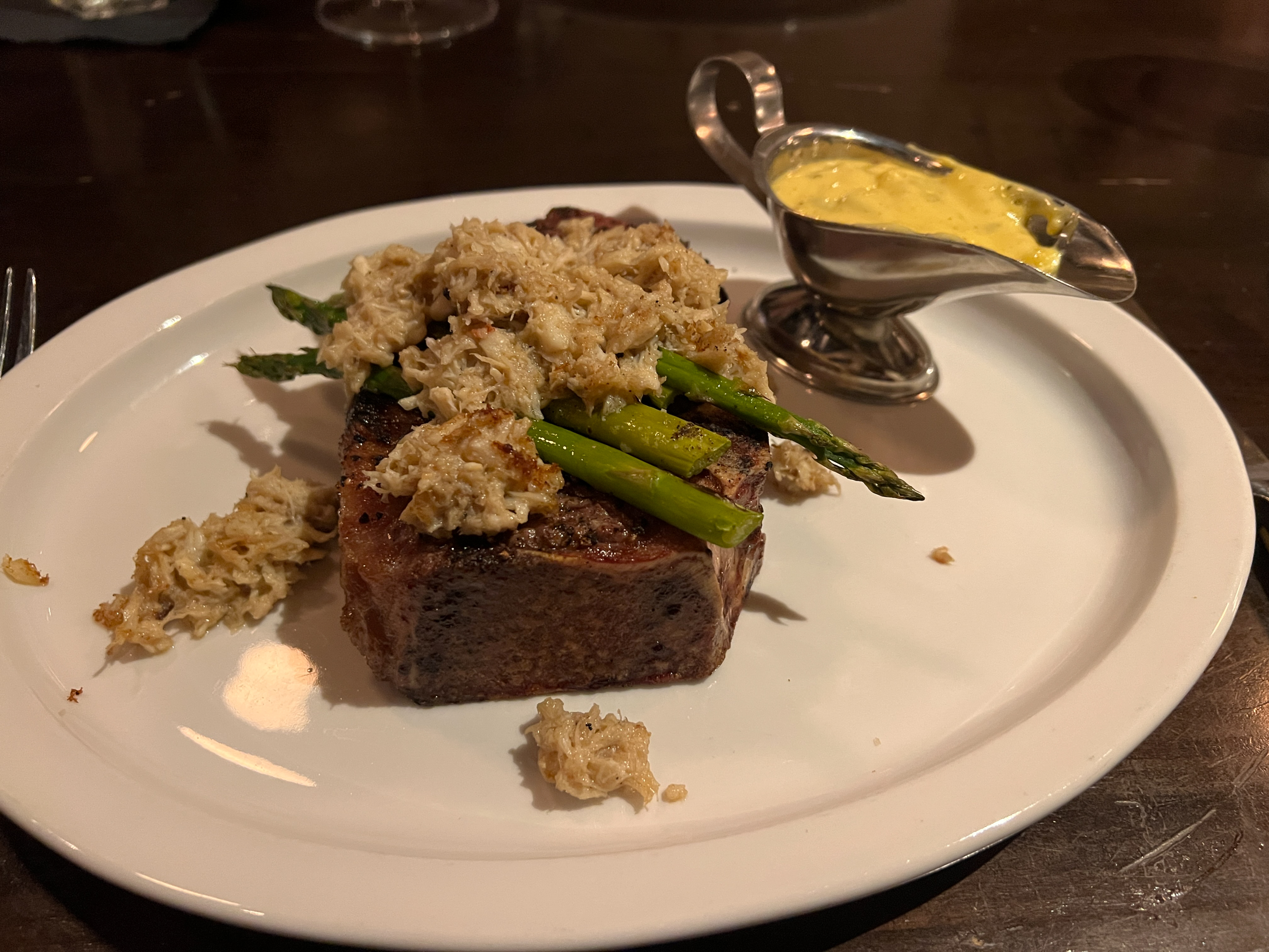 Steak Oscar at 117 Prime: a New York strip cooked very rare (to the author's order) covered in crabmeat and asparagus spears, served with bearnaise sauce. Photo by Sierra Harrop.