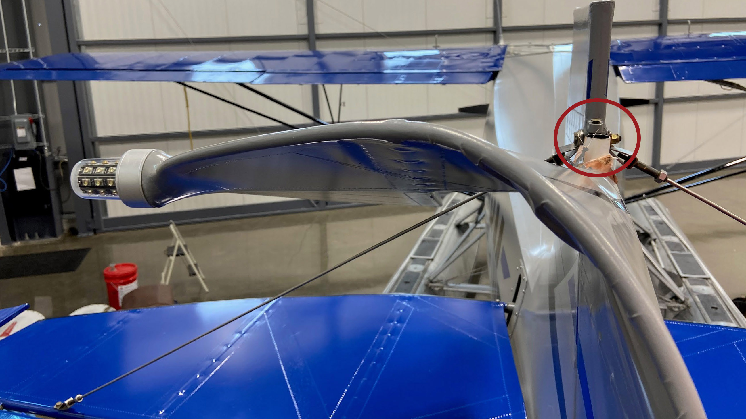 A Piper PA–12 on floats became nearly impossible to control after the airplane's rudder post fractured above the upper hinge (circled) on June 8, 2020, causing the top of the rudder to fold over in flight, one of two in-flight failures investigated by the NTSB, and among five rudders found to have similar failures, as  the NTSB documented in a recent report. NTSB photo.