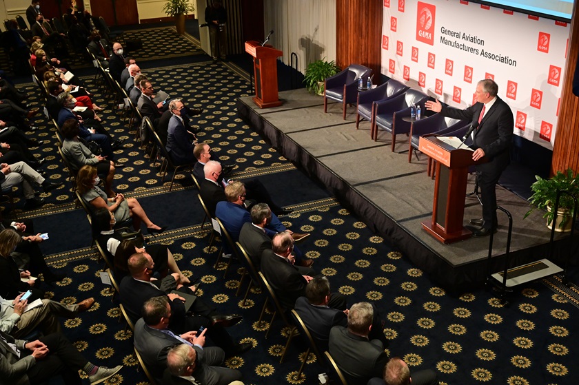 Media and VIPs including AOPA President Mark Baker (front row center) listen to a briefing on 2021 aircraft shipments and billing data, followed by the unveiling of a pledge to eliminate lead from aviation fuel by 2030, during the General Aviation Manufacturers Association State of the Industry event. Photo by David Tulis.