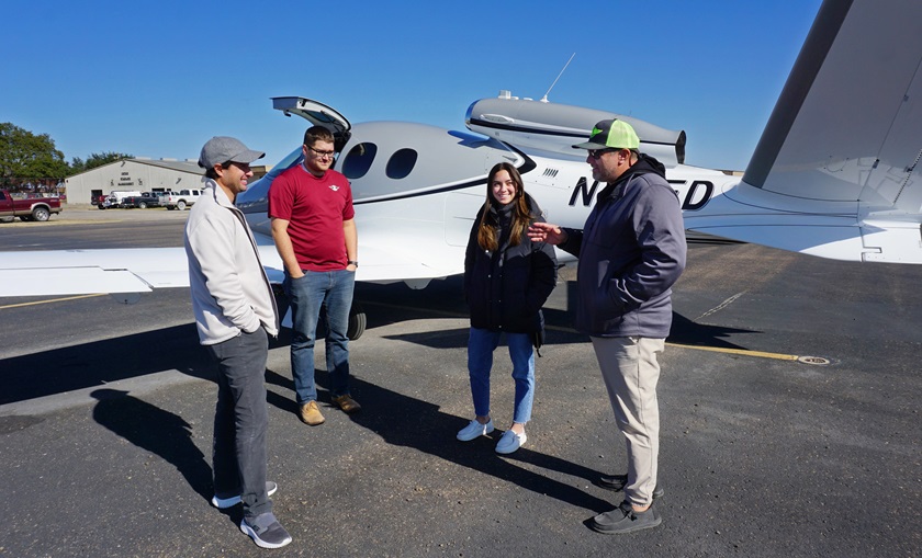 Angelina and David Tumbarello chat with a Cirrus Vision Jet owner and pilot on the ramp at Garner Field. Photo by Cayla McLeod.