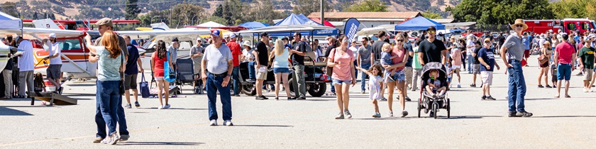 Food Truck Fly-In attendees walk the flight line of aircraft, food trucks, and flight schools. Photo by Joshua Lapum Photography.