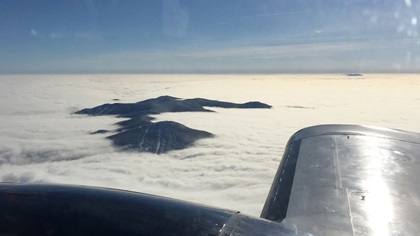 Two popular Vermont ski resorts rise through a thin undercast layer near Southern Vermont Regional Airport in Rutland: Pico, foreground, and the larger Killington behind Pico. This cloud composition is common during winter in the Green Mountain State. Photo courtesy of Charlie Rockwell.
