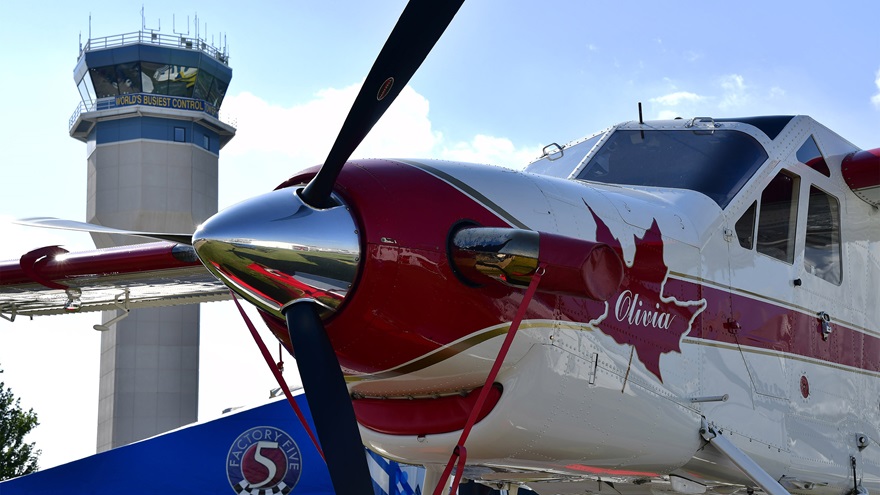 The iconic air traffic control tower at Wittman Regional Airport is framed by a de Havilland DHC-2 turbine-powered Beaver in Oshkosh, Wisconsin, in 2018. Photo by David Tulis.