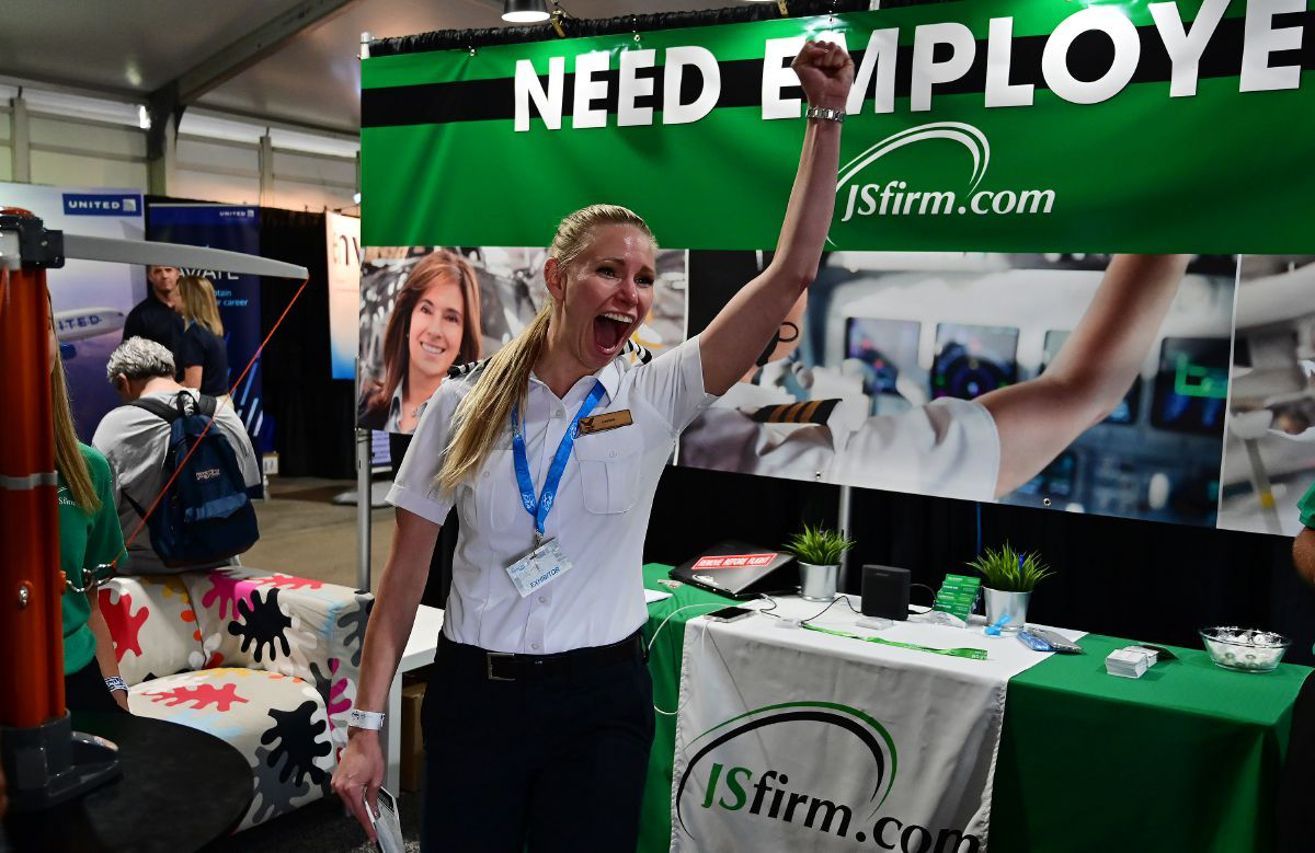 Airline pilot Crystal Frost reacts after winning a “hook ‘em” game at the JSfirm jobs booth in the EAA AirVenture Education and Career Center. Frost said traffic was about 50 percent higher in 2021 than in 2019 for young pilots asking her about aviation careers. Photo by David Tulis.