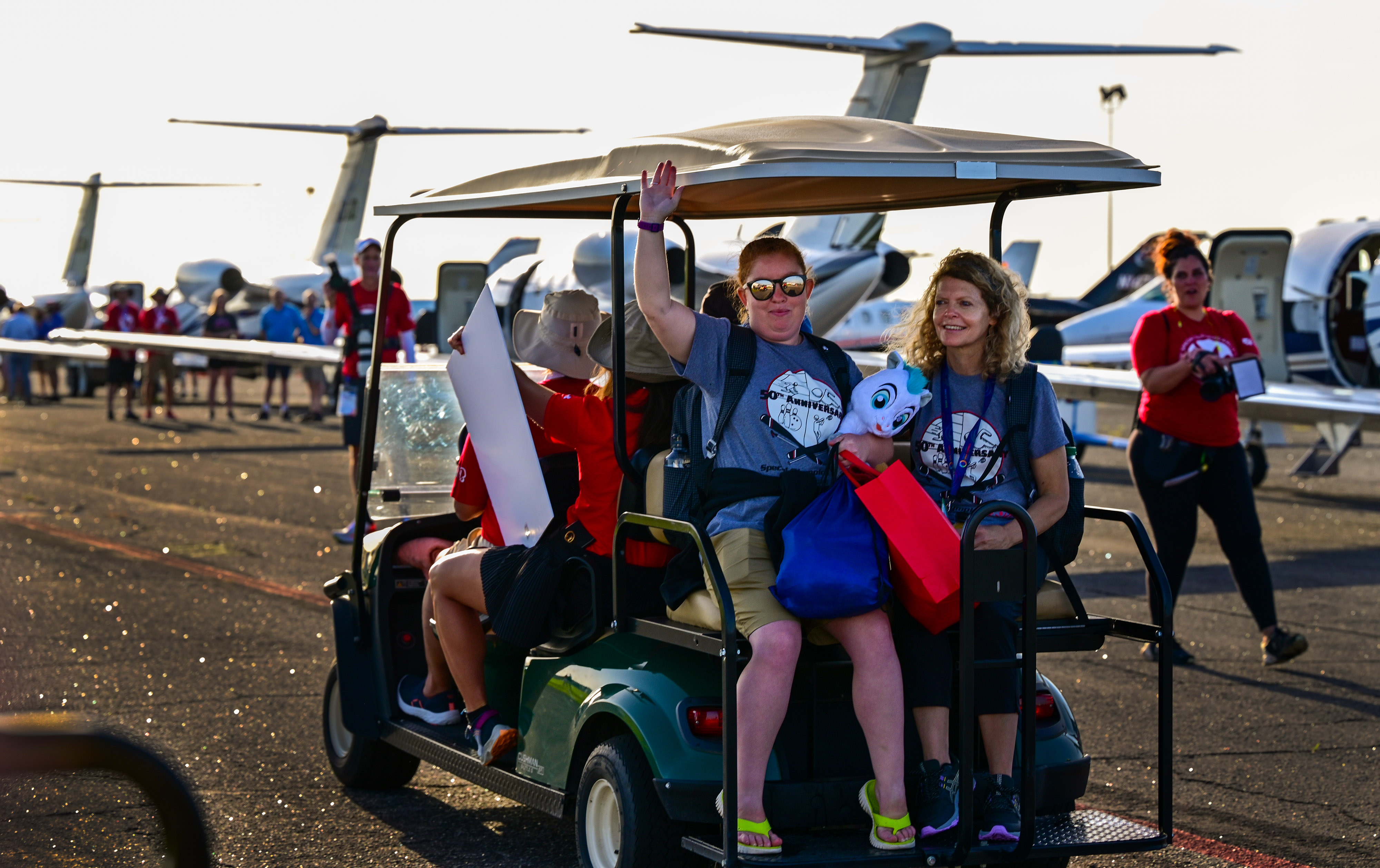 A Special Olympics USA athlete waves before departing from Orlando Executive Airport in the Textron Aviation-sponsored Special Olympics Airlift. Photo by David Tulis.