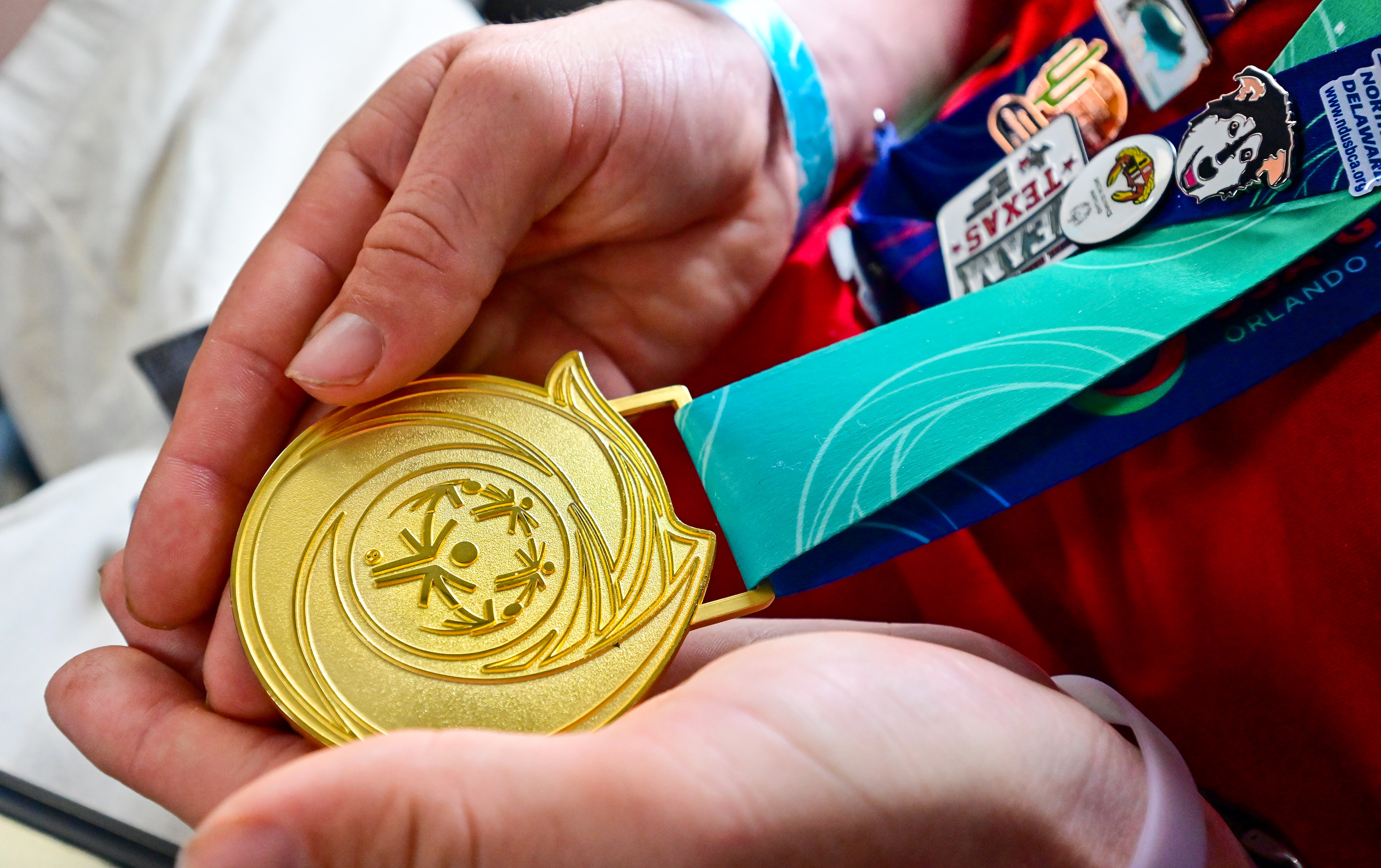 Special Olympics USA Games powerlifter Brian Beirne cradles his gold medal during the Dove 122 Special Olympics Airlift flight from Orlando, Florida, to Trenton, New Jersey. Photo by David Tulis.