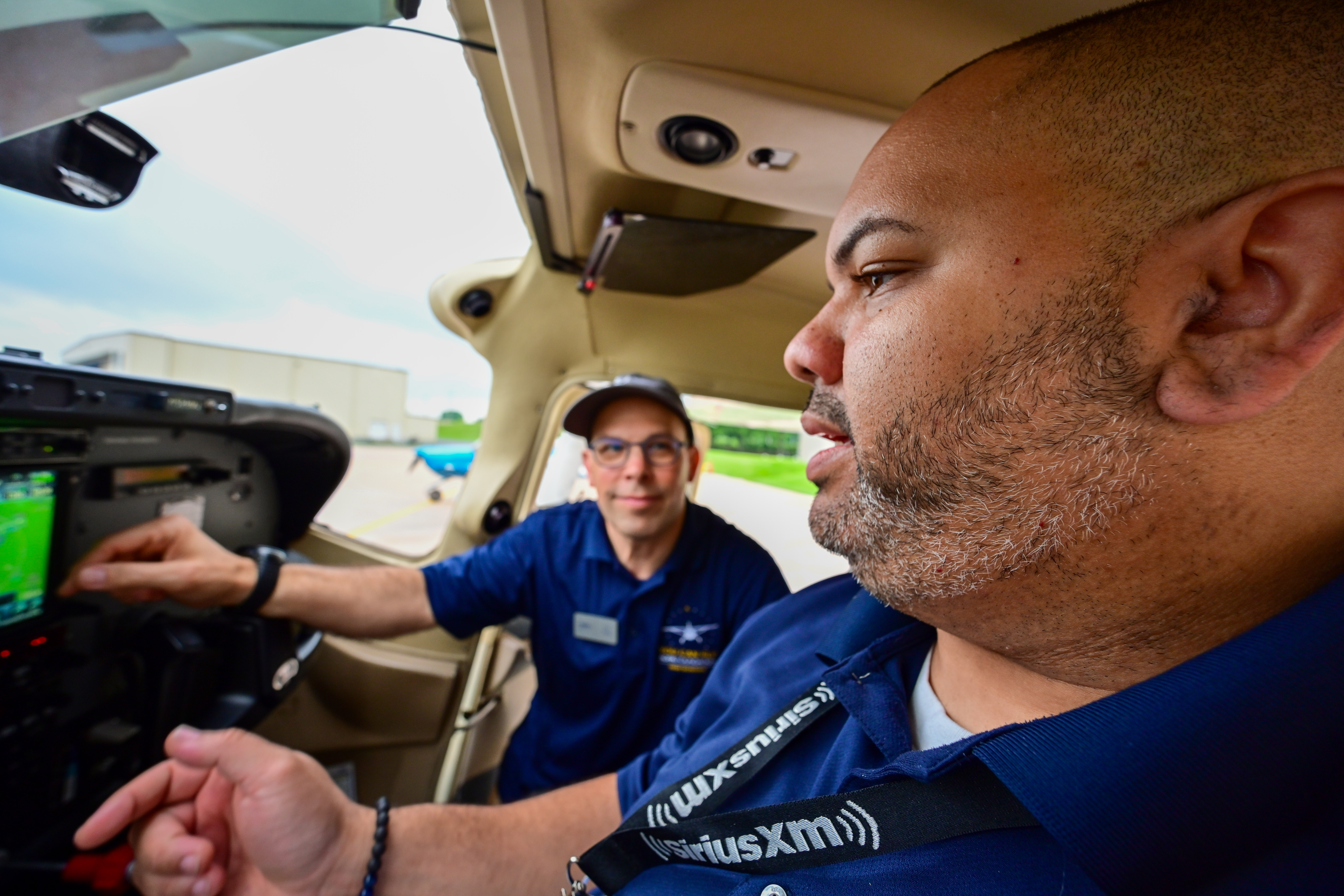 High school teacher Raymond Gonzalez of the Bronx, New York, learns about avionics and flight controls of a Cessna 182 Skylane from AOPA Director of Curriculum Development Erik Yates. Photo by David Tulis.