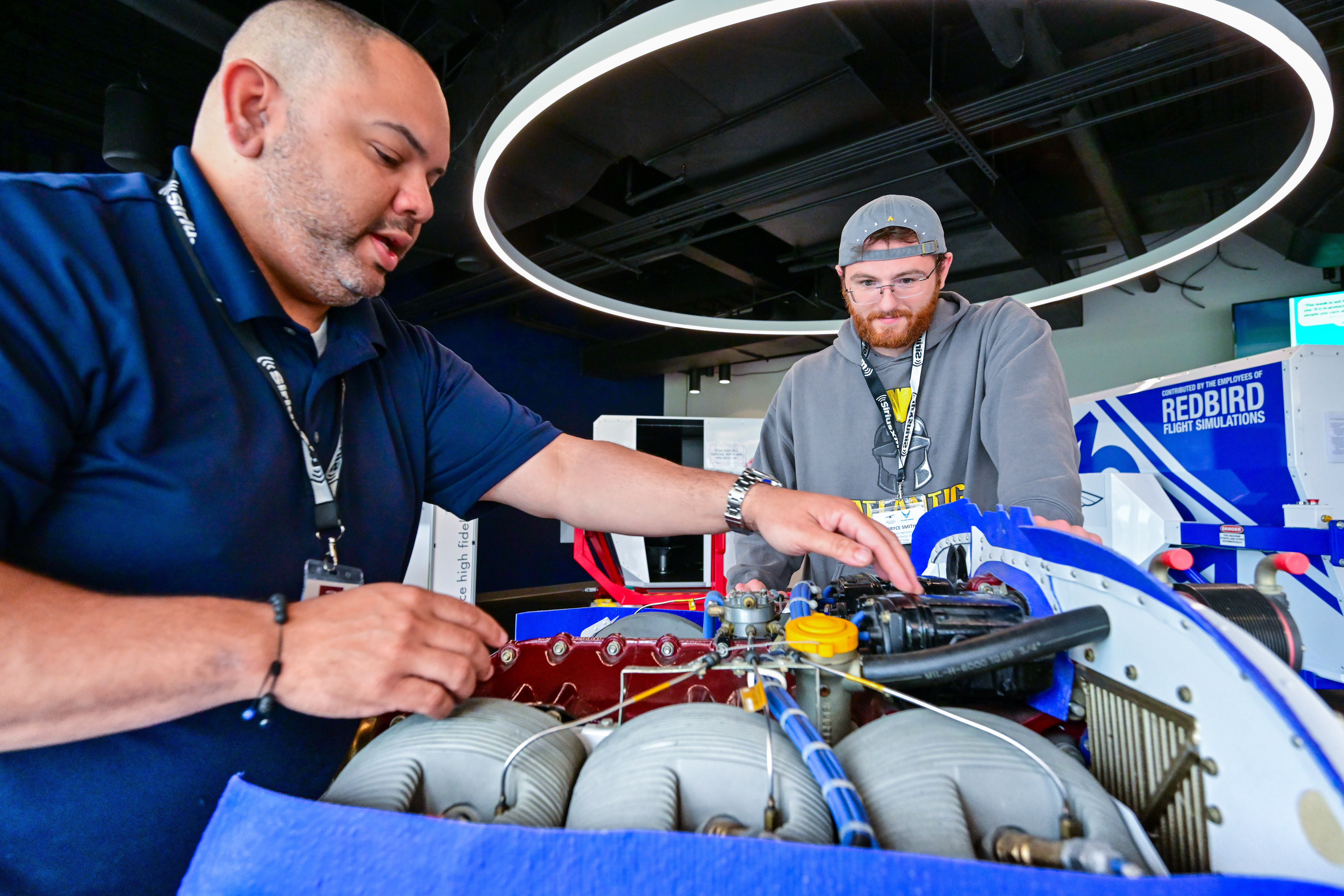 High school educators Raymond Gonzalez, left, of the Bronx, New York, and Bryce Smith of Port Orange, Florida, explore a six-cylinder aircraft engine during hands-on exercises to bolster their understanding of science, technology, engineering, and math skills as they relate to aviation in Frederick, Maryland, June 14. Photo by David Tulis. 