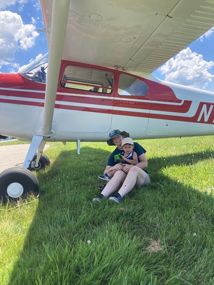 Visitors to Goodspeed Airport for the second annual fly-in hosted by Young Pilots USA sought shade under the wing of an airplane. Photo by Lillian Geil.