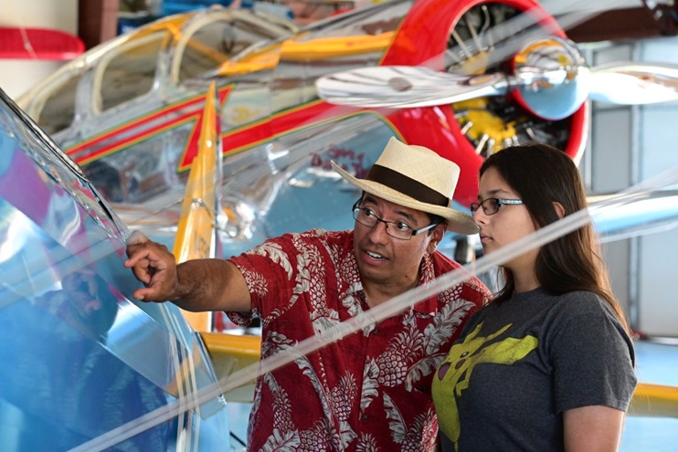 Felix Lopez teaches daughter Vivian about the fabric-and-tube design of a Boeing Stearman at Triple Tree Aerodrome in Woodruff, South Carolina. The aerodrome is offering four $2,500 scholarships as a part of its Aviation Centered Education program. The deadline to apply is March 7. Photo by David Tulis. 