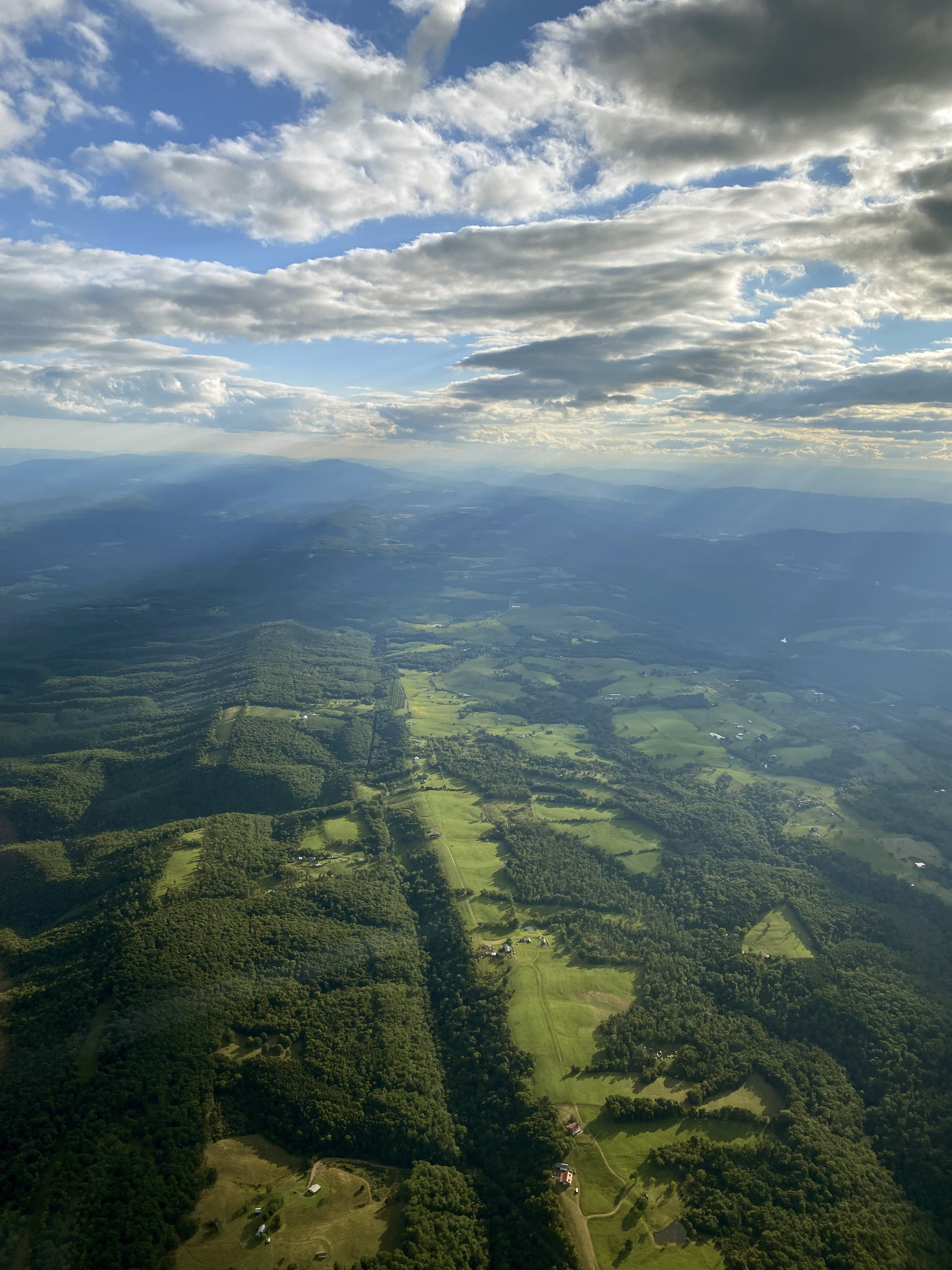 Rippling Appalachian foothills are dappled with trees and sunbeams. Photo by Alyssa J. Cobb.