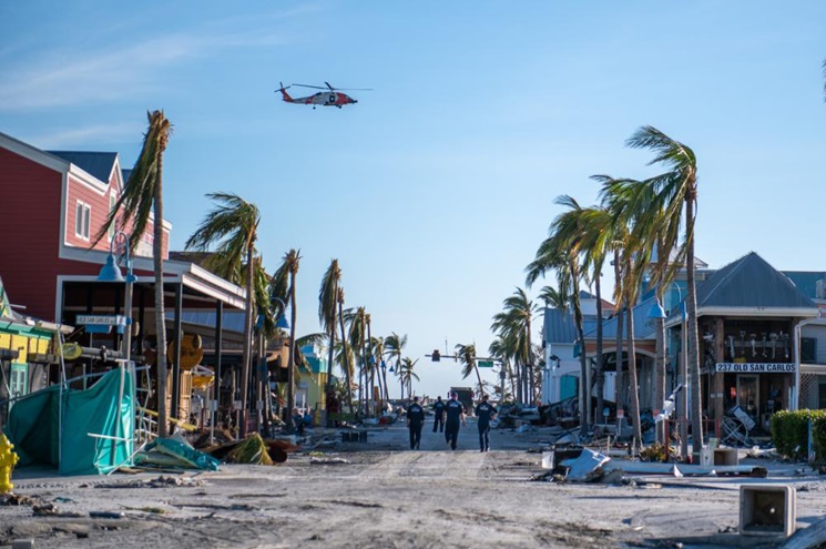 A Coast Guard Air Station Clearwater MH–60 Jayhawk flies over Fort Myers Beach, Florida, on September 29 scanning for people while Coast Guard National Strike Force team members search on the ground. U.S. Coast Guard photo by Petty Officer 3rd Class Gabriel Wisdom.