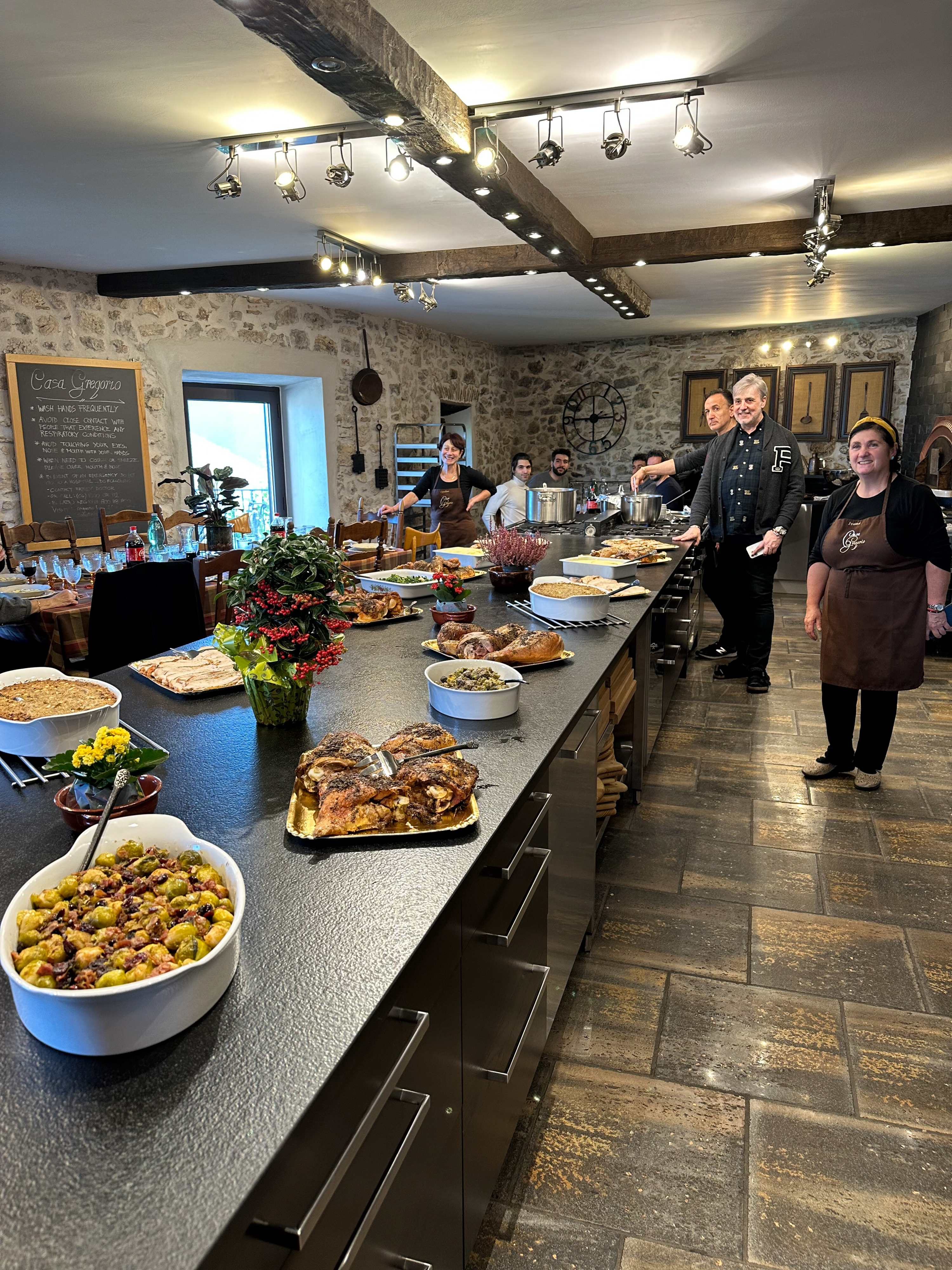 Gregory Aulensi, owner/developer of Casa Gregorio, A Roman Countryside Culinary Holiday, and some of his staff proudly display a portion of their 2022 Thanksgiving feast in the spacious, fully equipped commercial kitchen. Photo by Mary Michael.