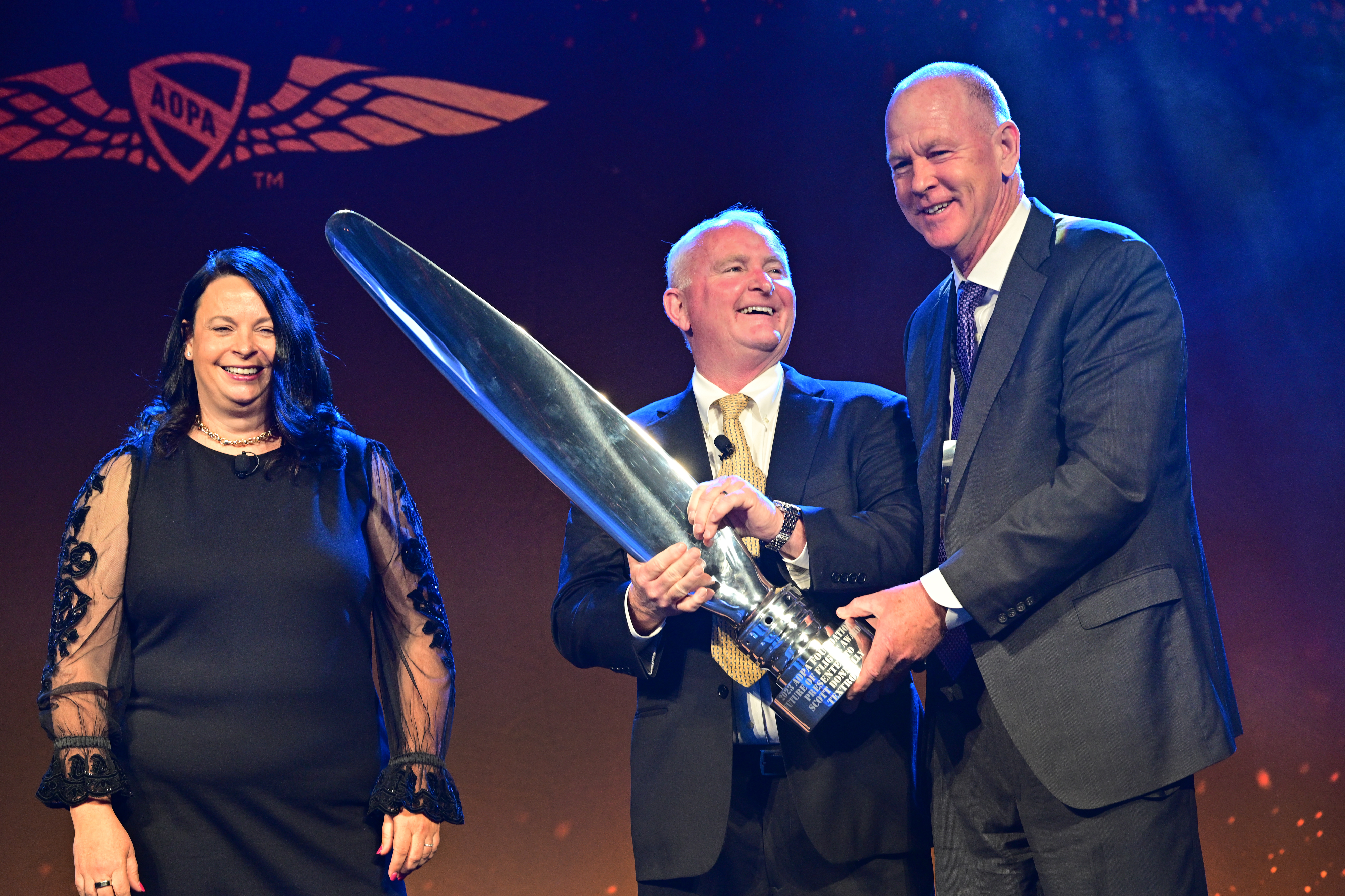 AOPA Foundation Senior Vice President Elizabeth Tennyson and AOPA President Mark Baker present Textron CEO Scott Donnelly with the Future of Flight Award. Photo by David Tulis.