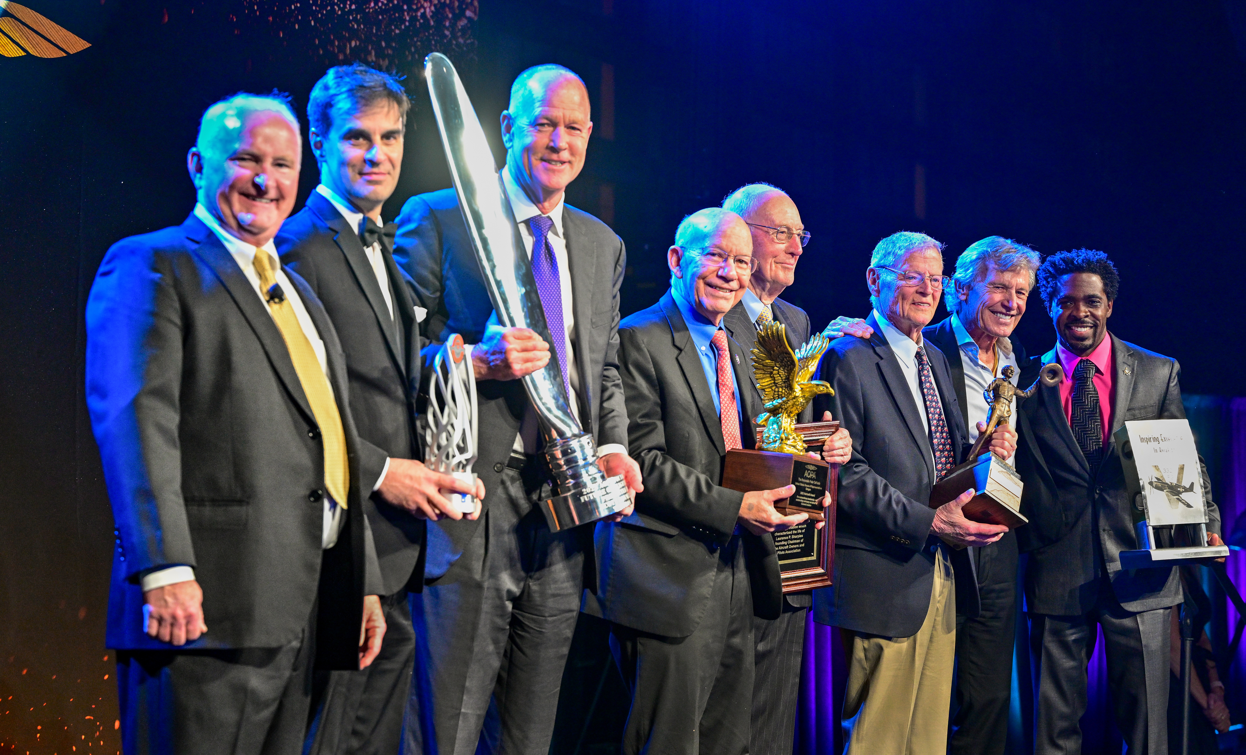 Award winners join AOPA President Mark Baker and master of ceremonies Sean D. Tucker on stage. Photo by David Tulis.