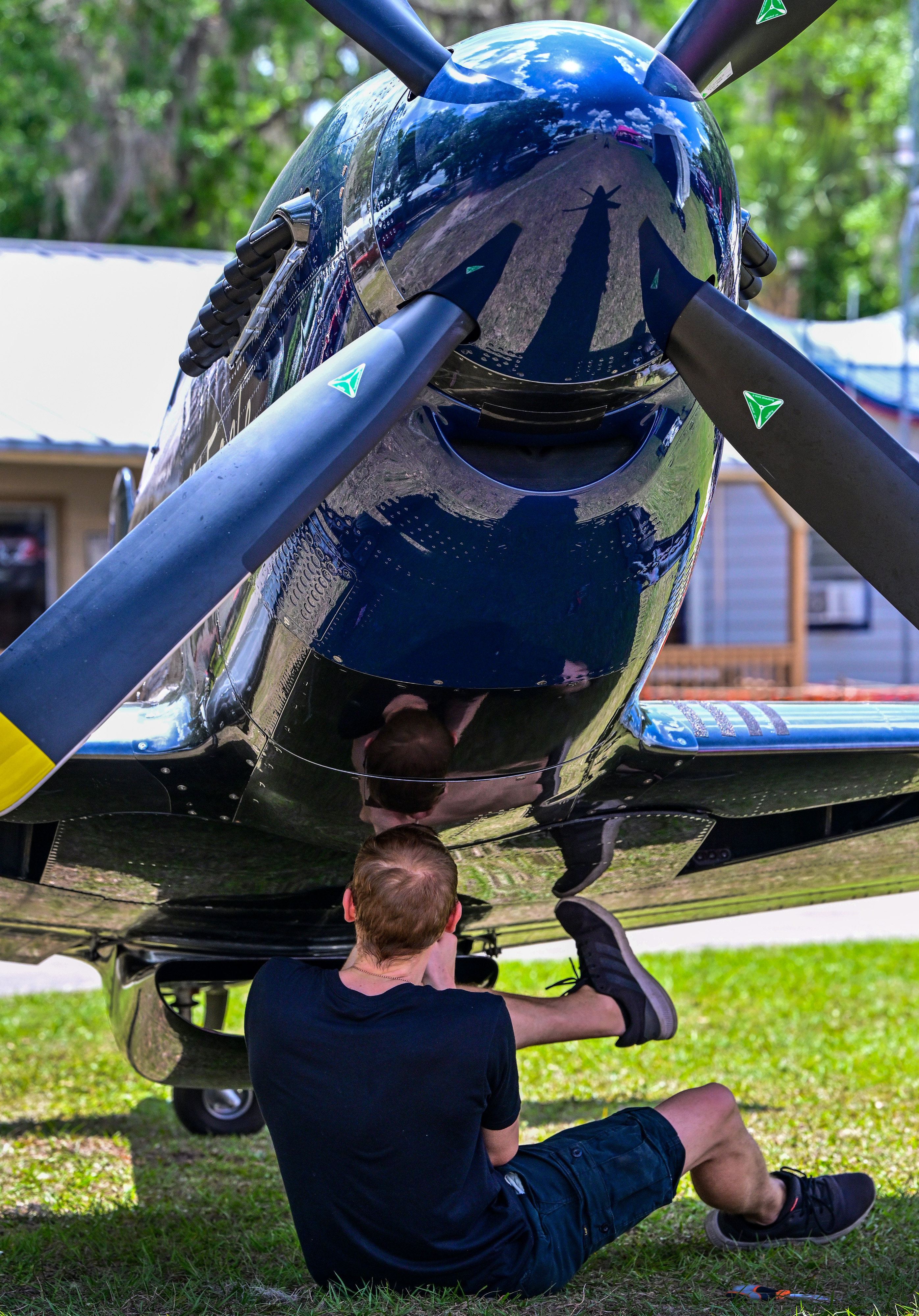 Simon Schell uses his hands and feet to work on a ScaleWings carbon fiber P-51 Mustang replica in the display area. Photo by David Tulis.