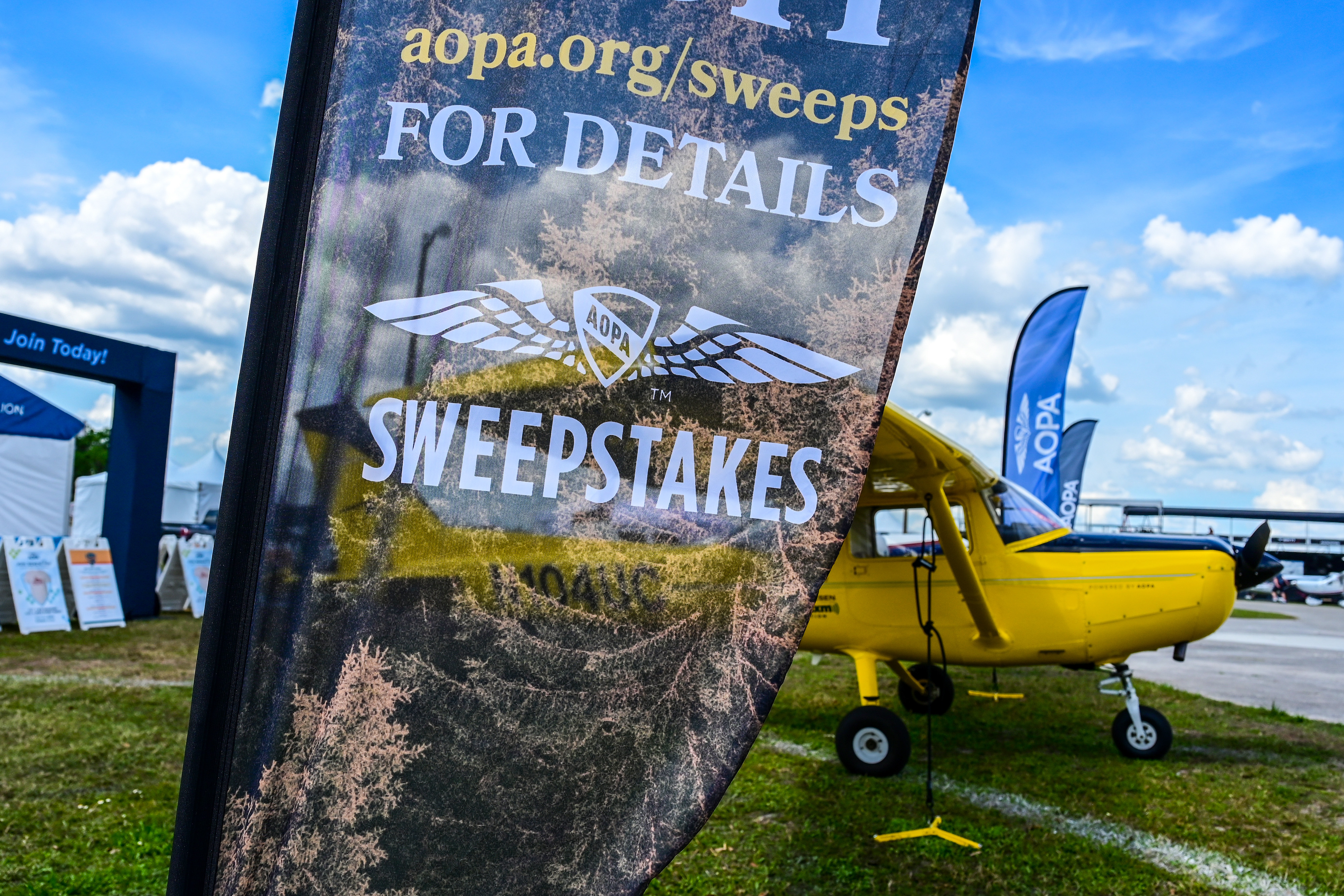 A yellow Cessna 152 is featured on the AOPA campus during the Sun ’n Fun Aerospace Expo. Photo by David Tulis.