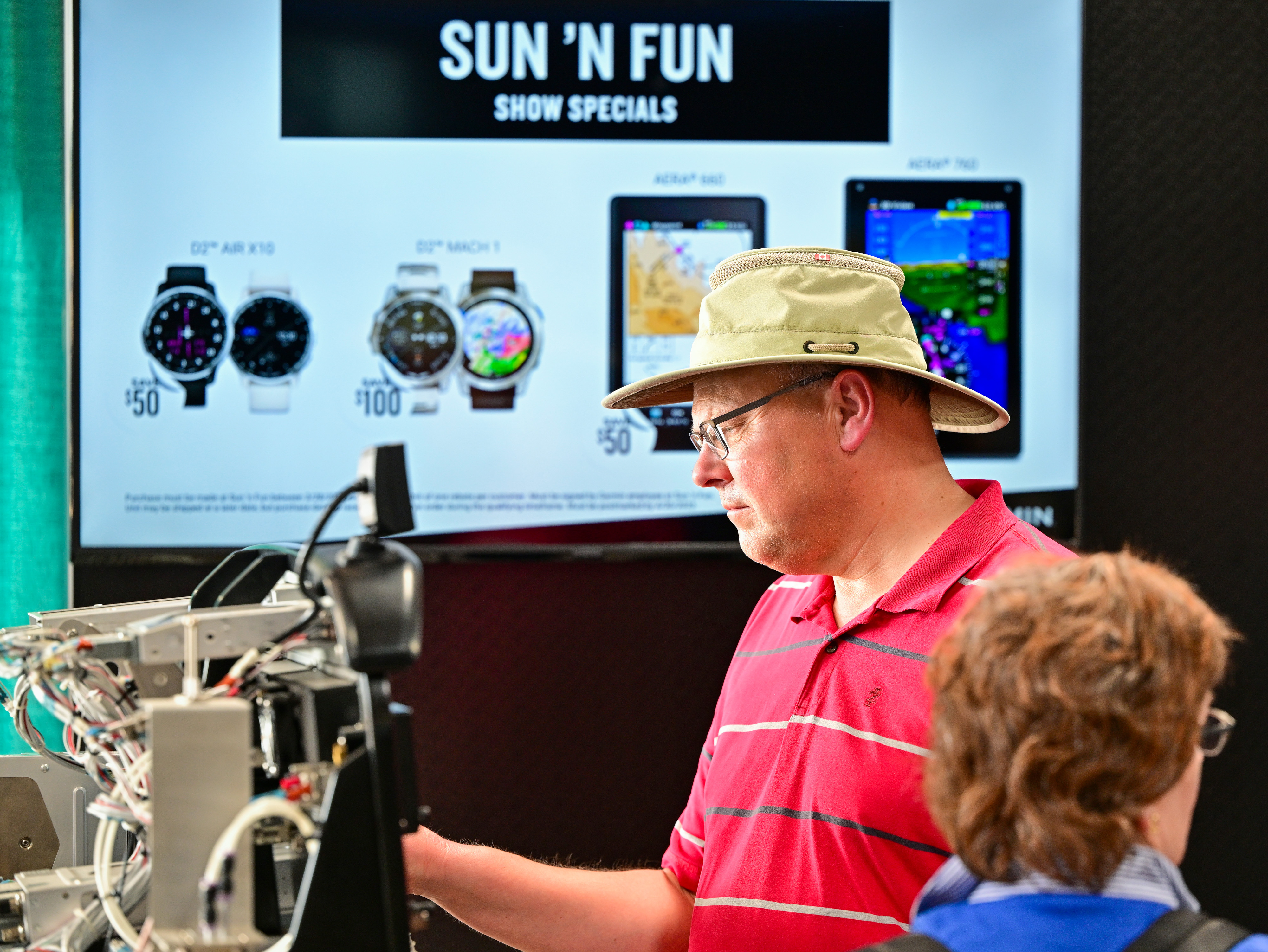 Glasair owner Mel Reister of Alberta, Canada, views Garmin aircraft avionics near a sign announcing show specials during the Sun 'n Fun Aerospace Expo. Photo by David Tulis.