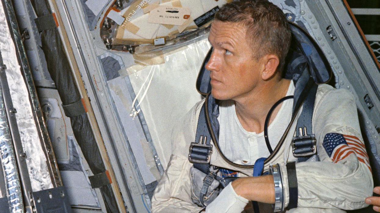 Astronaut Frank Borman, command pilot for the Gemini 7 spaceflight, looks over the mission's spacecraft during weight and balance tests. NASA photo.
