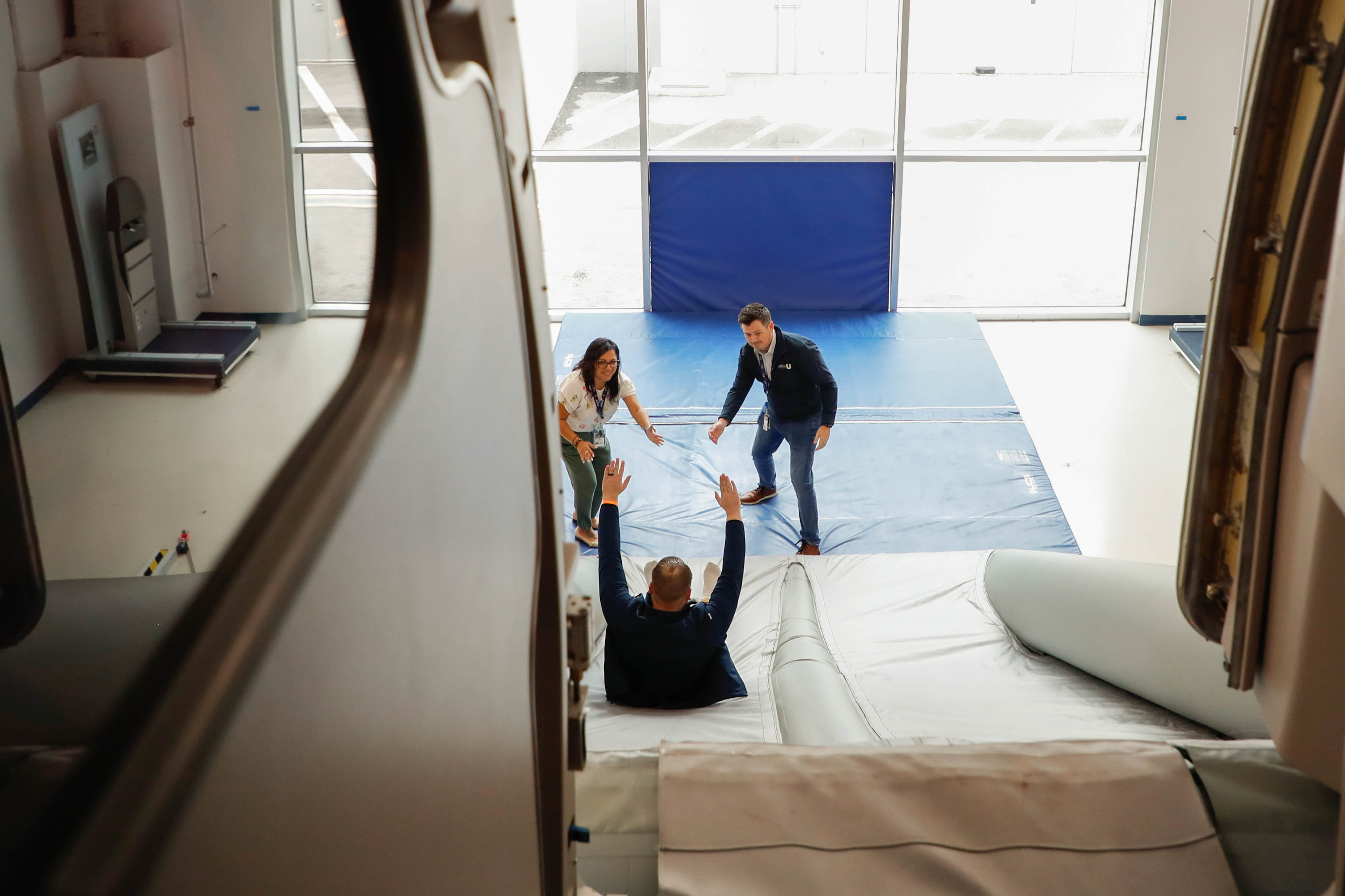 Attendees experience firsthand an airplane emergency evacuation slide during a tour of the JetBlue University training center. Photo by Rebecca Boone.