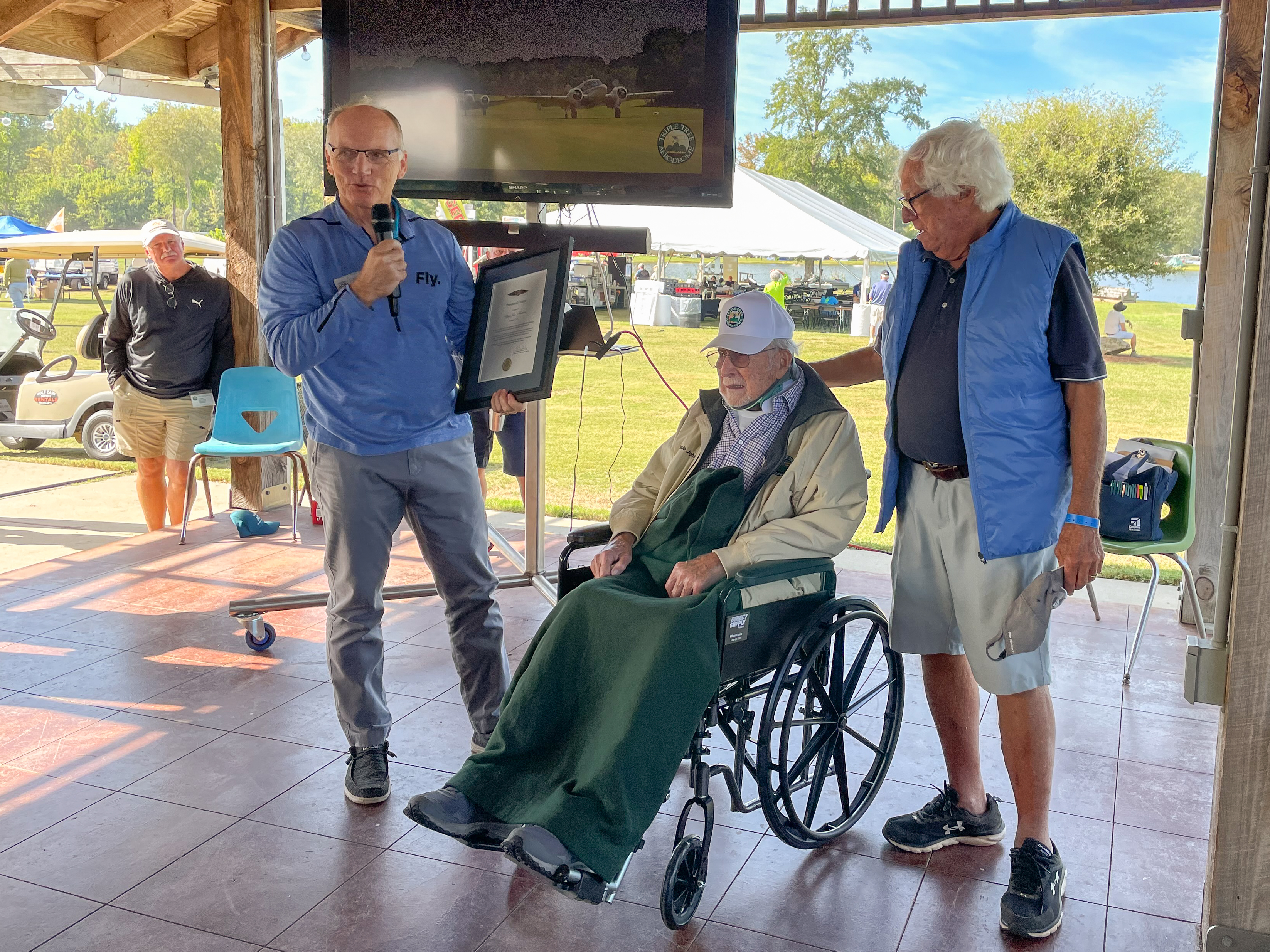 The late Richard McSpadden (left), senior vice president of the AOPA Air Safety Institute, provided fly-in attendees an AOPA update and then awarded 'Uncle John' Hartness (center) an AOPA Presidential Citation, 'in spirit of his 100th birthday, for demonstrating a true passion for growing general aviation, especially among aspiring young aviators.' Triple Tree founder Pat Hartness (right) thanked Uncle John for his support in helping make the Triple Tree Aerodrome one of the premier destinations in the country. Photo by Kollin Stagnito.