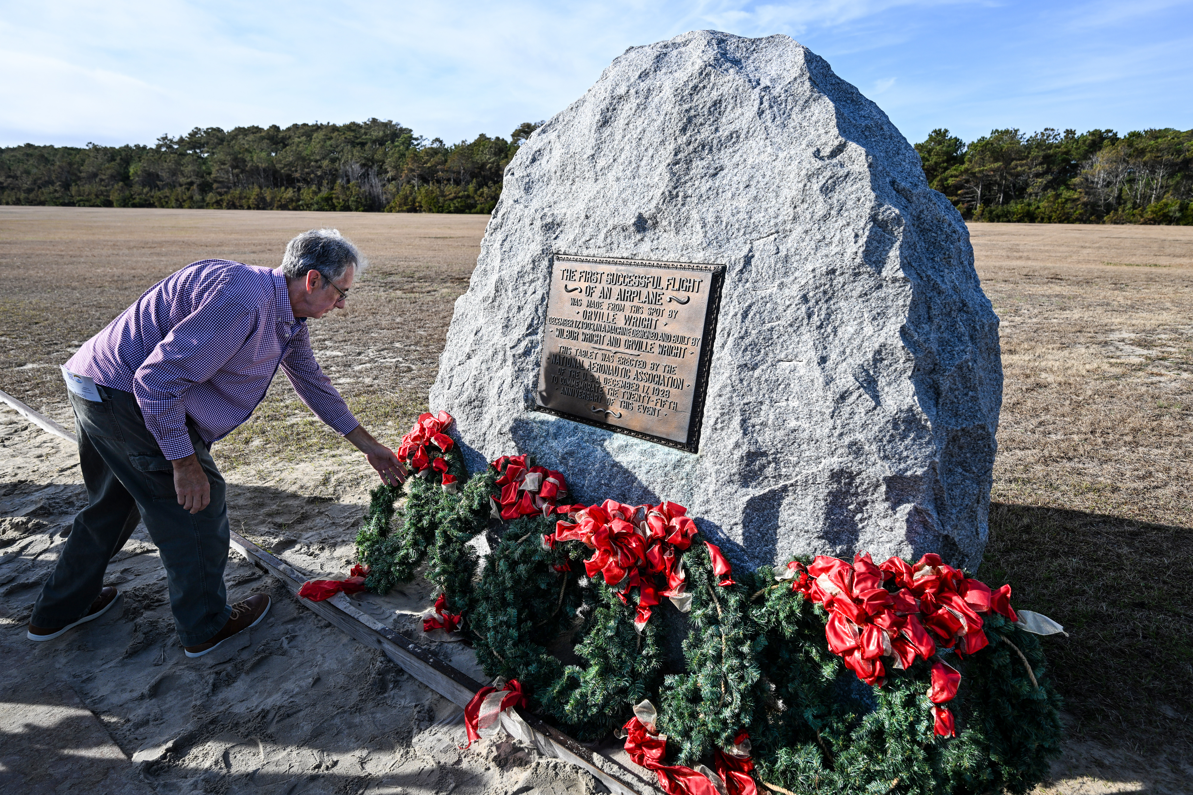 A wreath is placed at a tablet erected in 1928 to recognize the accomplishments of Orville and Wilbur Wright and their successful first powered flight. Photo by David Tulis.