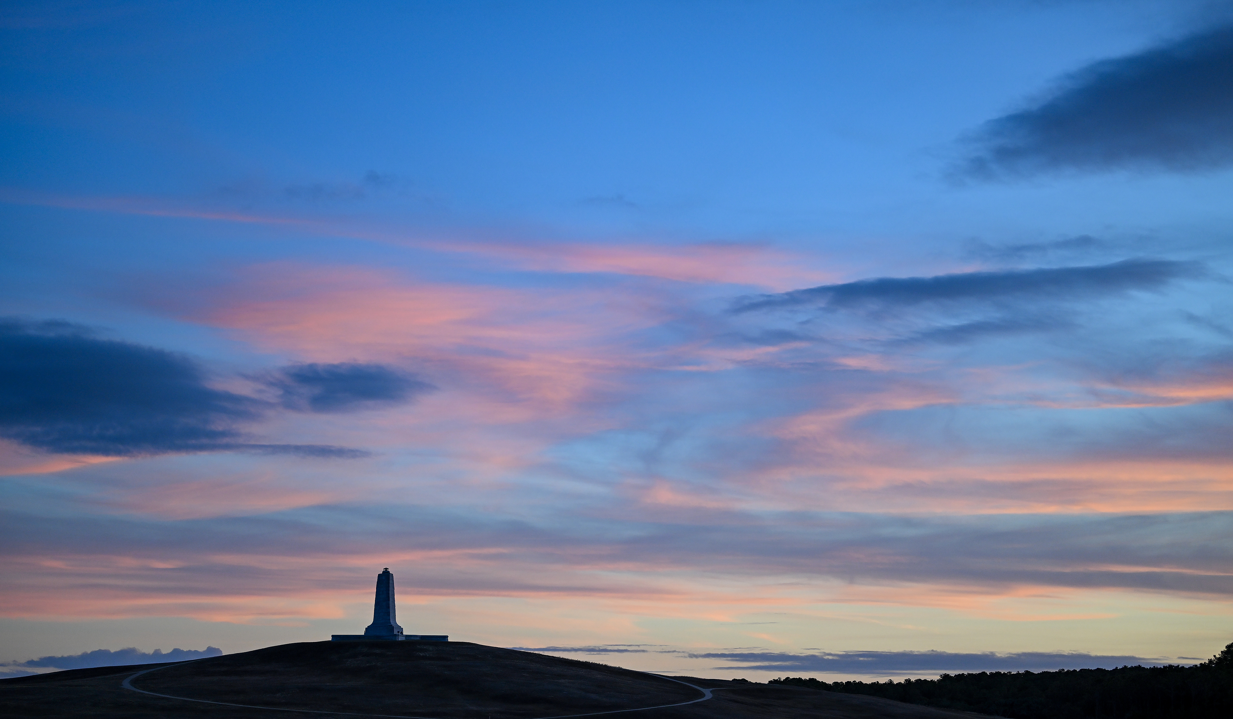 A setting sun illuminates the monument at the Wright Brothers National Memorial in Kill Devil Hills, North Carolina. Photo by David Tulis.