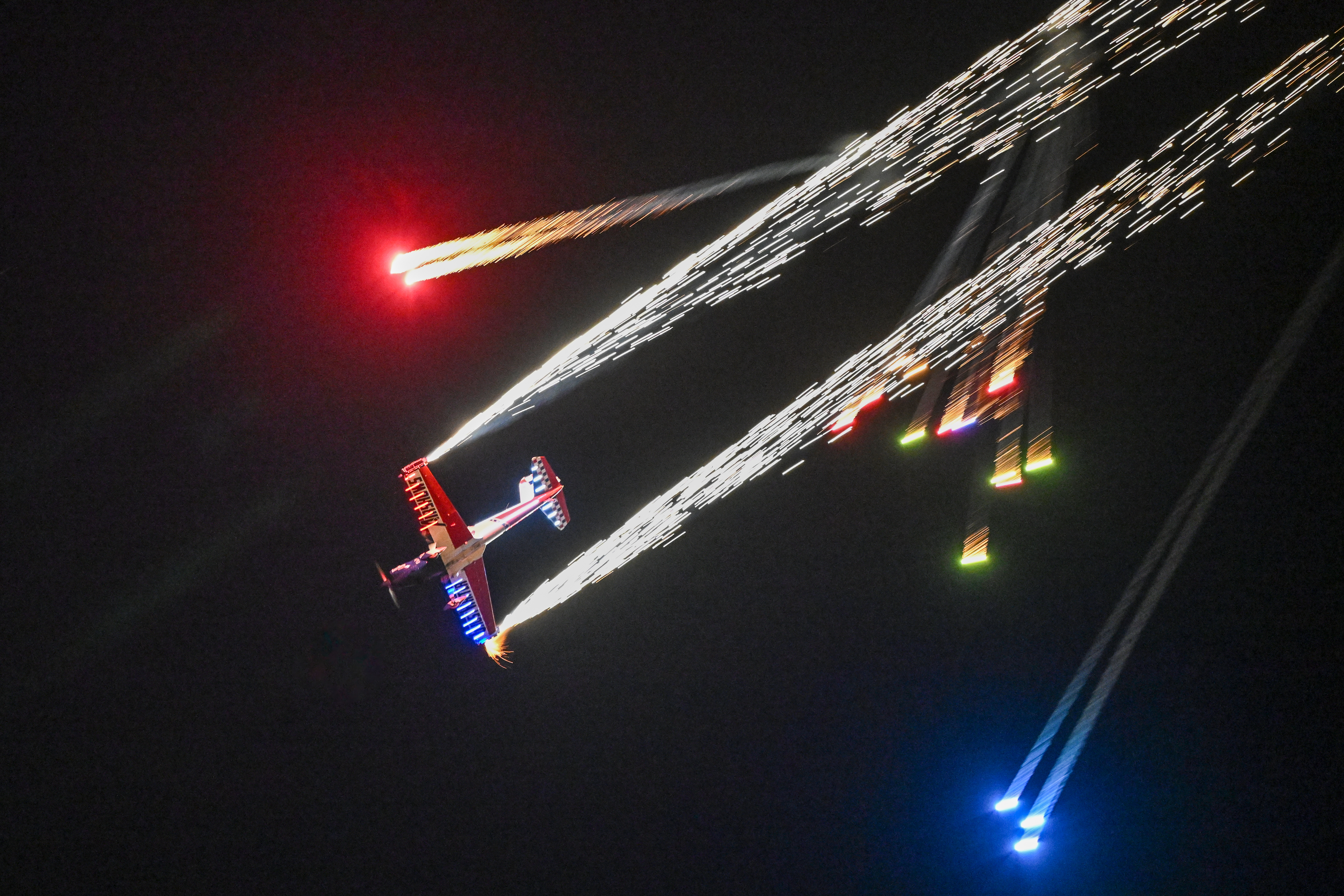 GhostWriter Airshow performer Nate Hammond fires pyrotechnics from his de Havilland Super Chipmunk during the night airshow. Photo by David Tulis.