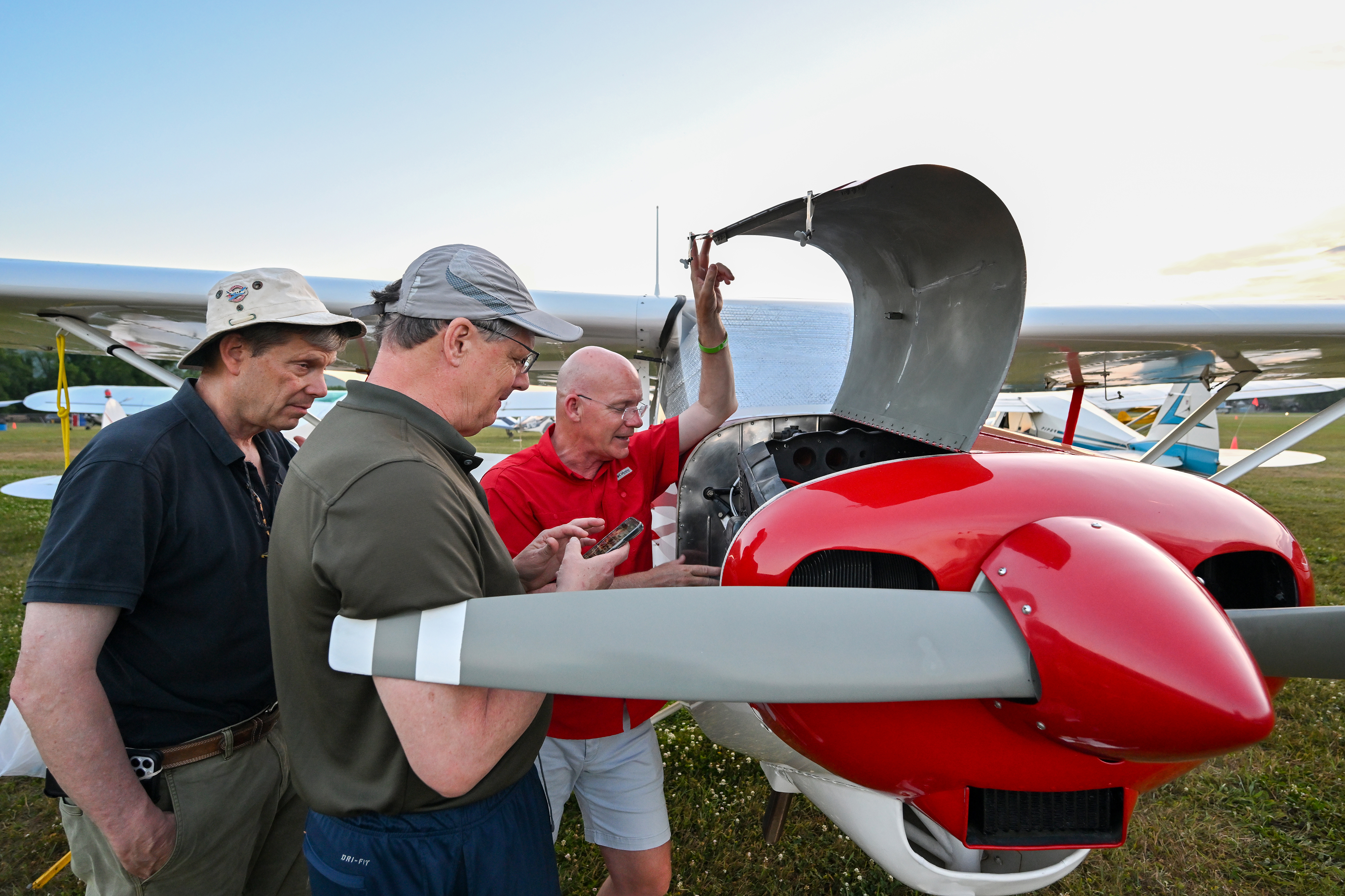 Scott Hinton shows the engine compartment of his Piper Tri-Pacer to attendees. Hinton is the airport director at Elizabeth City Regional Airport in North Carolina, and he purchased his aircraft after spotting it during the Short Wing Piper Club’s annual convention at his airport in 2023. Photo by David Tulis.