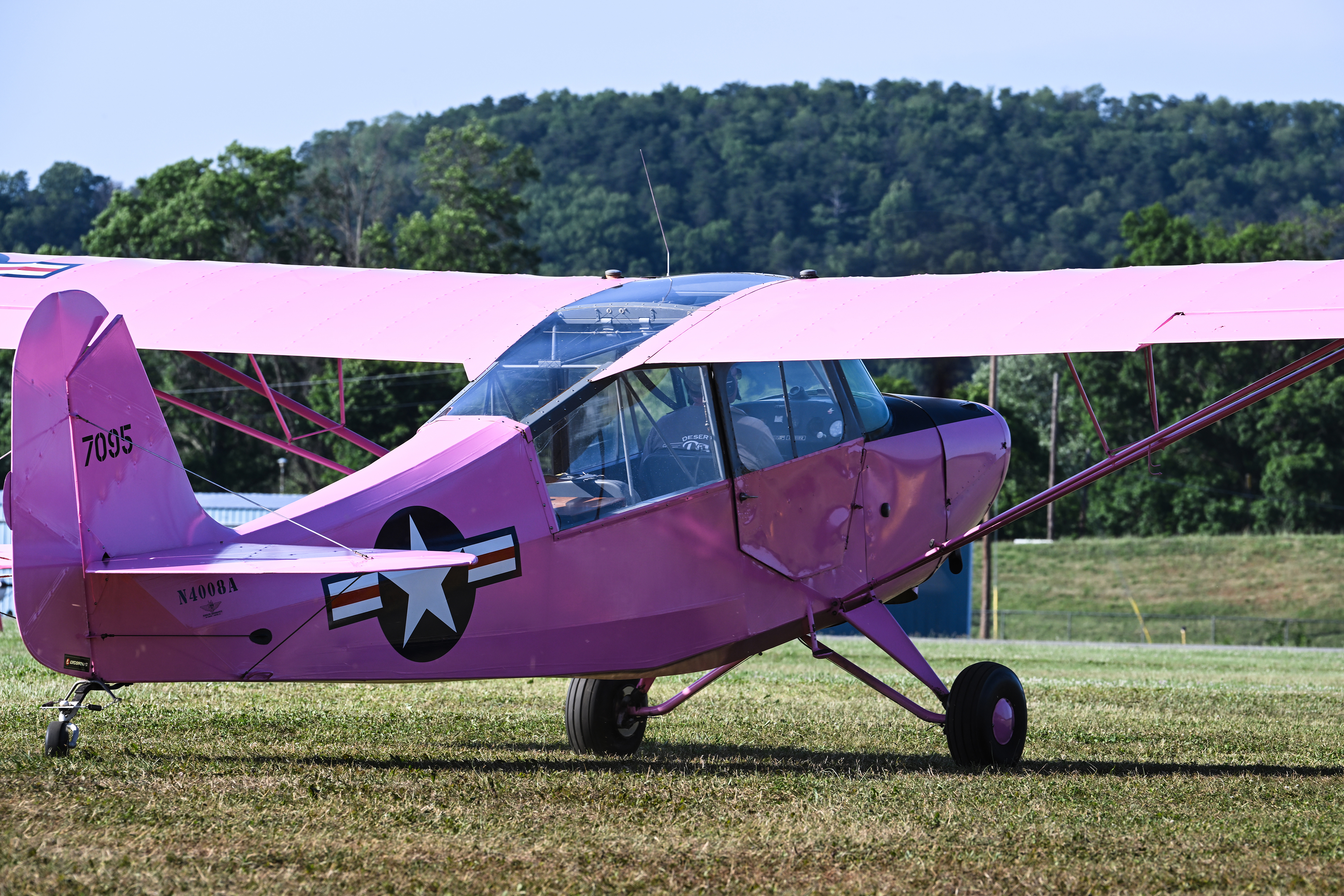 A pink 1947 Aeronca Champion liaison aircraft taxis out for an evening flight. Photo by David Tulis.