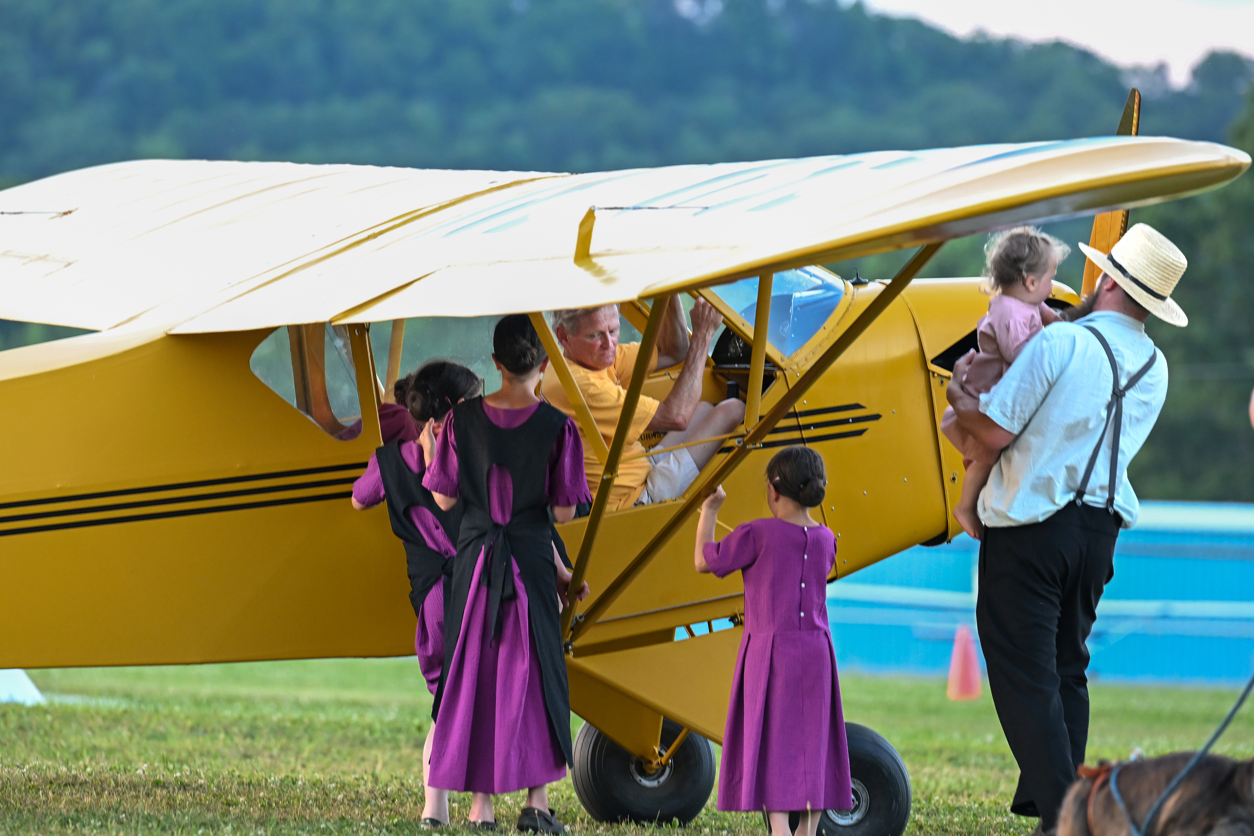 Amish community members visit with a pilot giving rides before sunset. The Loganton Amish agricultural community with fresh produce greenhouses and a grocery store is close to the airport. Photo by David Tulis.