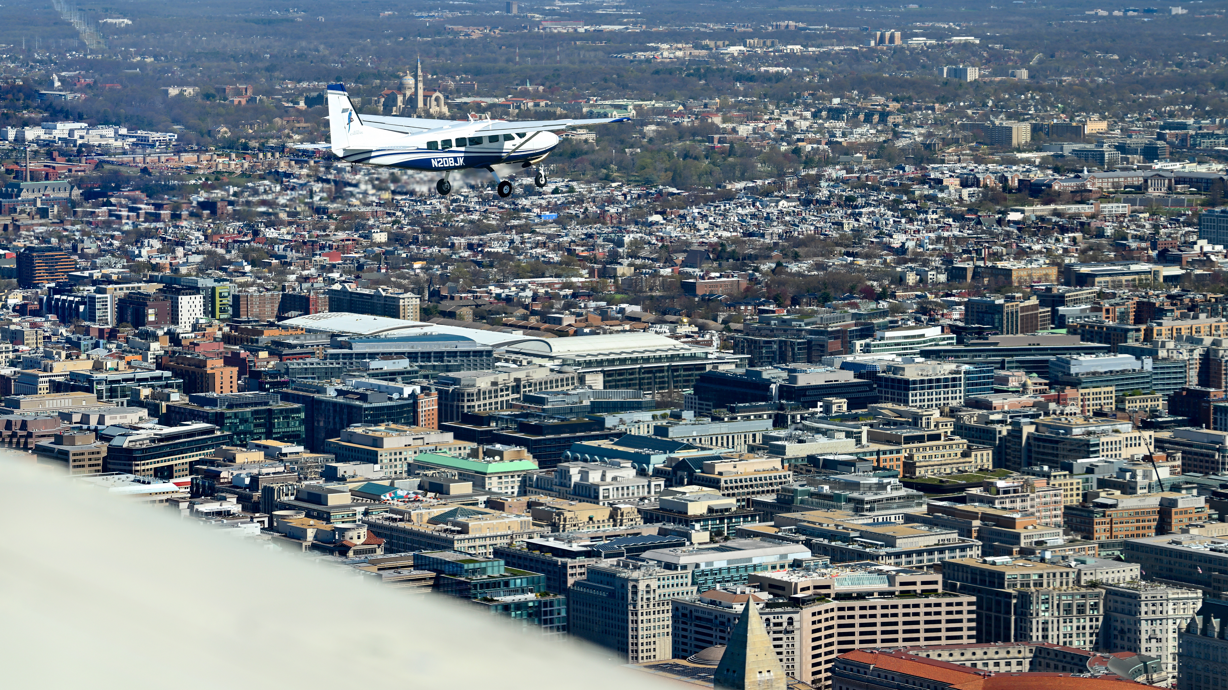 The top of the Washington Monument, lower right, appears below the photo aircraft as AOPA President Mark Baker pilots his Cessna 208 Caravan during a March 24 practice flight for a general aviation flyover of the National Mall in Washington, D.C., to help celebrate AOPA’s eighty-fifth anniversary scheduled for May 11. Photo by David Tulis.