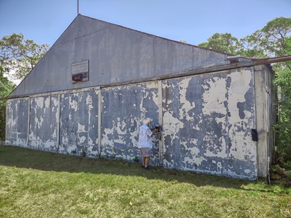 Michael Nagle, who helps manage Trade Wind Airport, unlocks the lone hangar where he keeps his Ximango motorglider and other aircraft. Photo by Jonathan Welsh. 