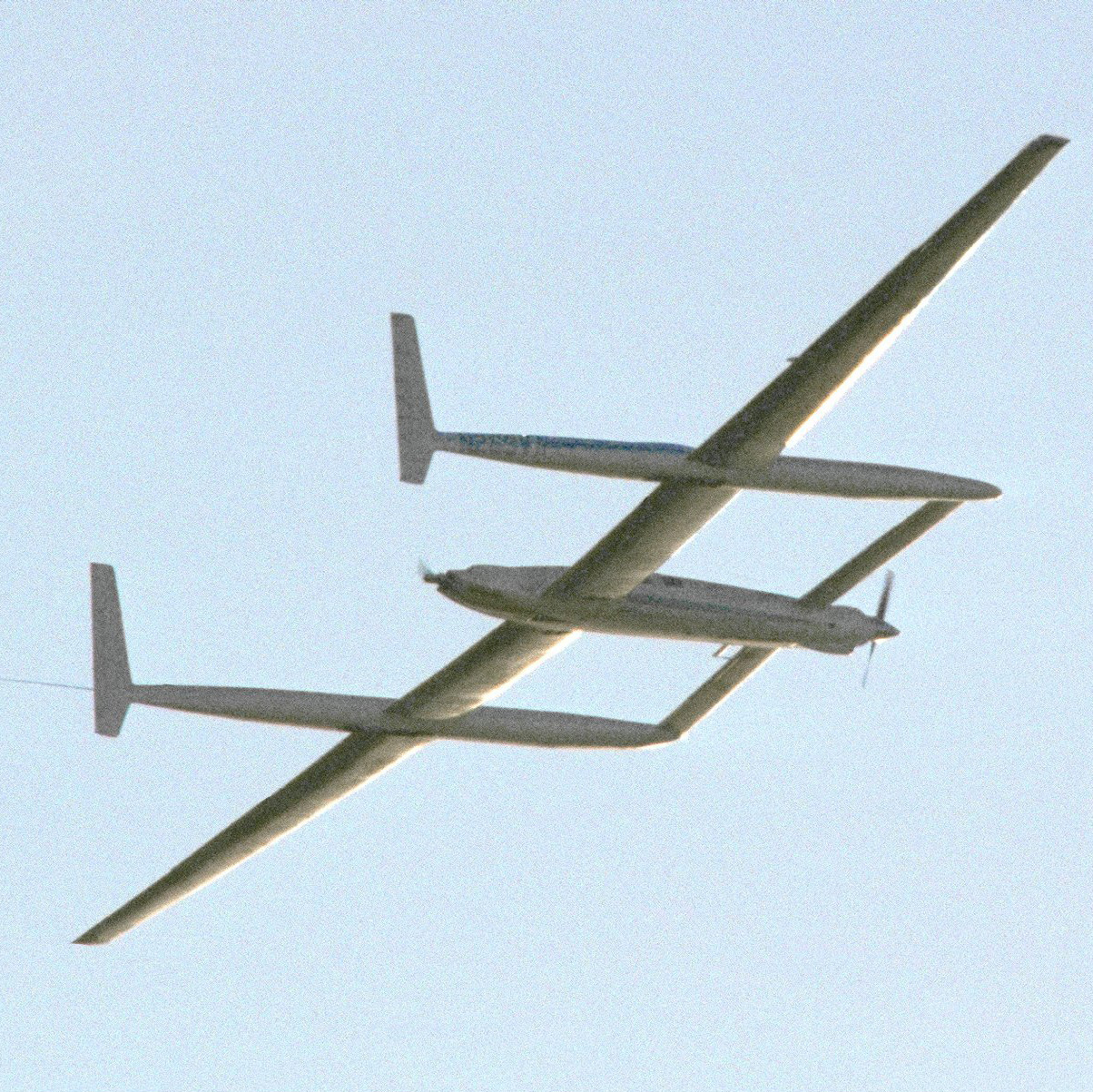 The 'Voyager' aircraft circles before landing at Edwards Air Force Base in California on December 23, 1986, completing a record-breaking, nonstop unfueled flight around the world. The aircraft's takeoff weight was more than 10 times the structural weight, but its drag was lower than almost any other powered aircraft. The nine-day, three-minute, 44-second flight nearly doubled the previous distance record set in 1962 by a U.S. Air Force Boeing B-52. NASA photo.