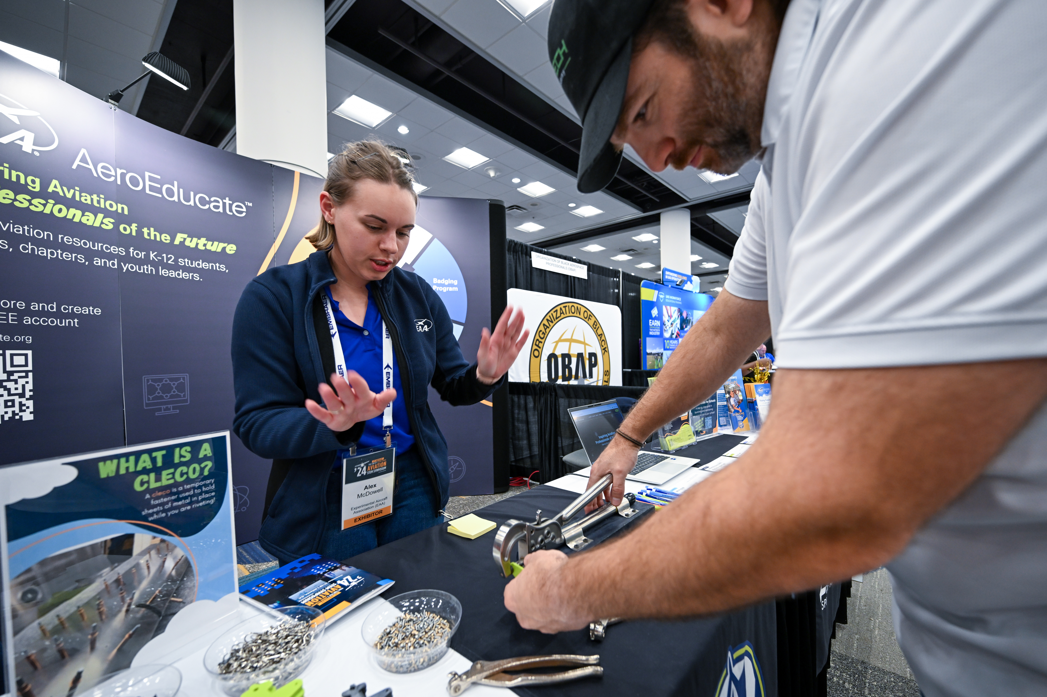 Alex McDowell provides hands-on riveting instruction to attendees at the Experimental Aircraft Association booth. Photo by David Tulis.