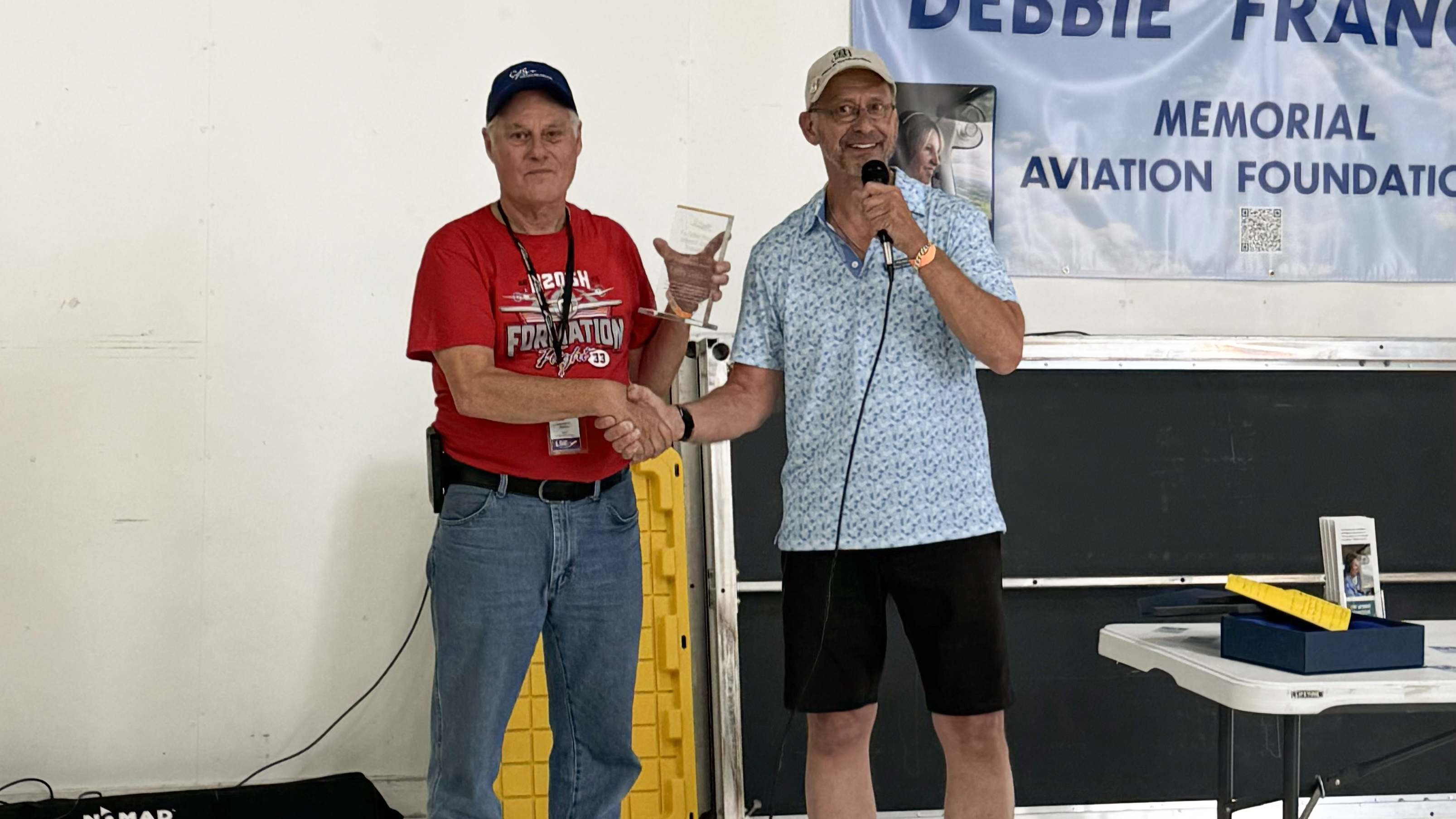 Mike Franceus, chairman and founder of the Debbie Franceus Memorial Aviation Foundation, presents the Aviation Spirit Award to Larry Gaines in La Crosse, Wisconsin, on July 19. Photo courtesy of Mike Franceus.