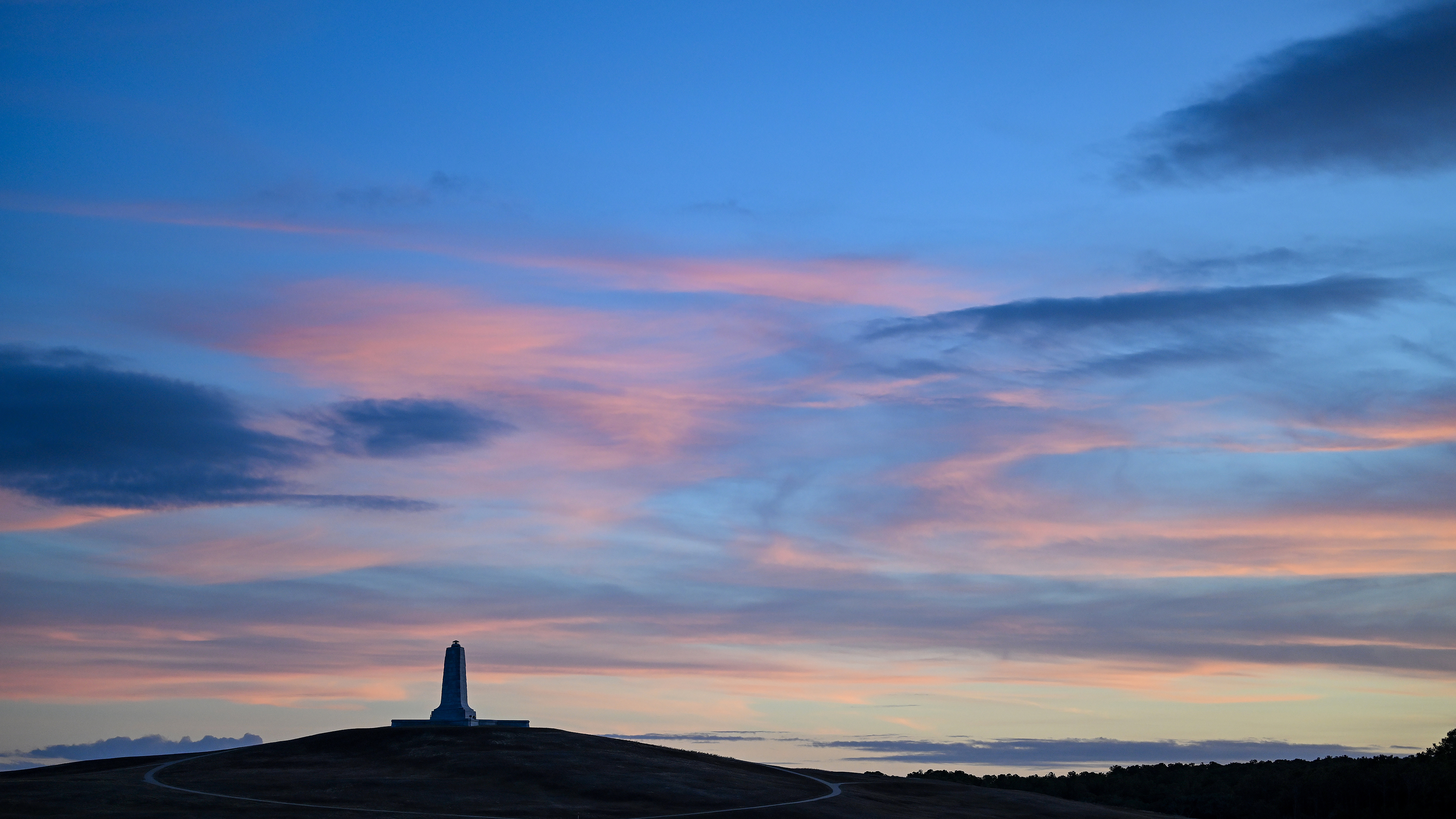 A setting sun illuminates the monument at Wright Brothers National Memorial in Kill Devil Hills, North Carolina. Photo by David Tulis.