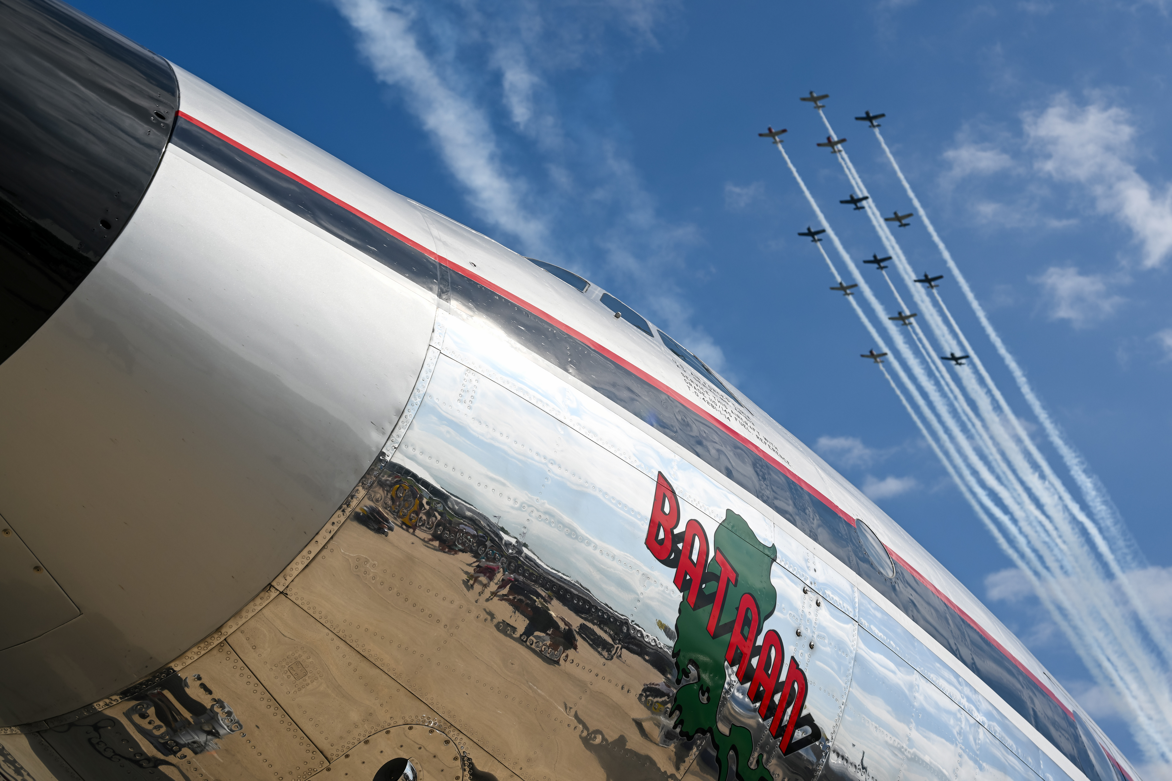Afternoon airshow performers fly over the nose art of the 'MacArthur Bataan' Lockheed C-121A Constellation. Photo by David Tulis.