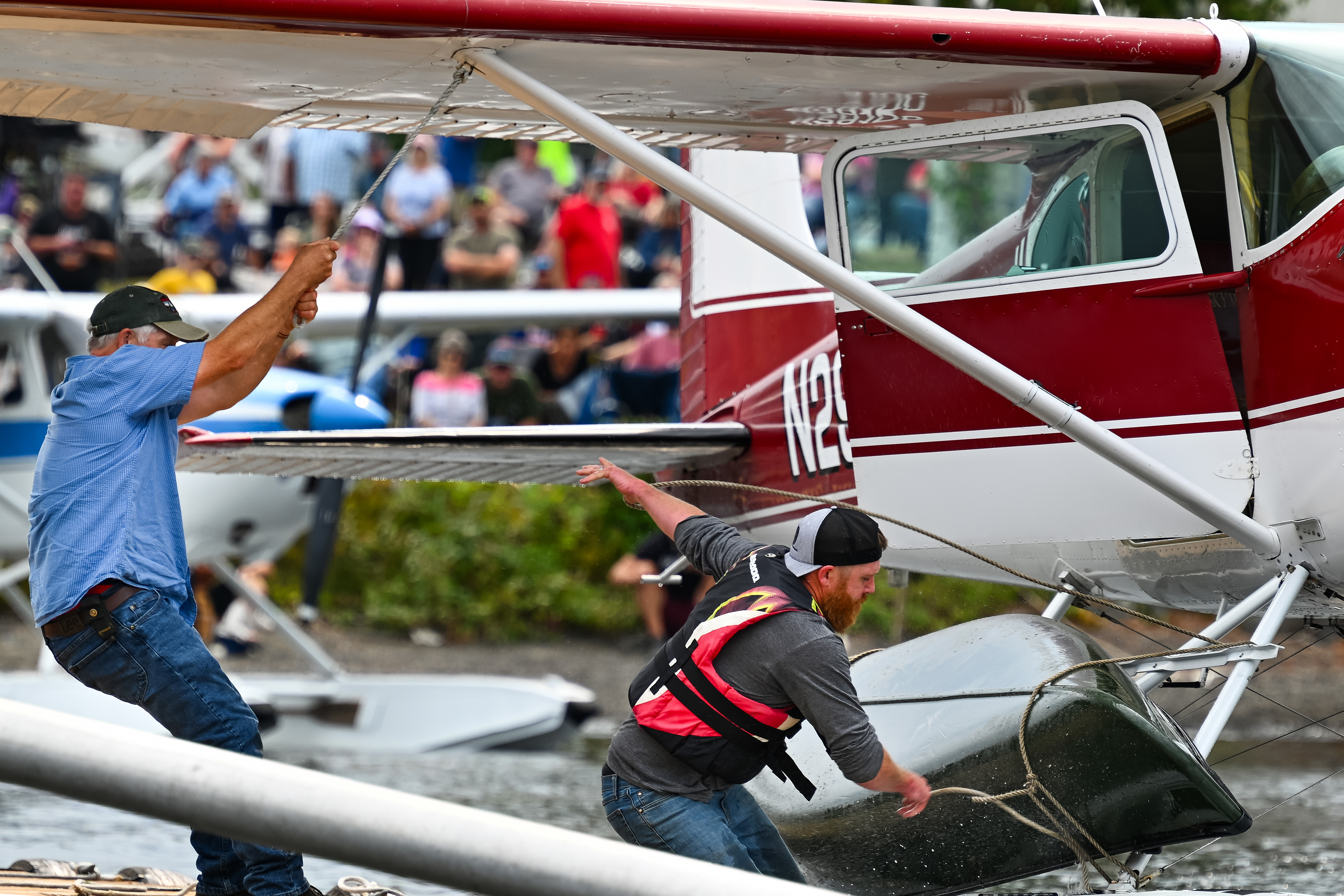 Paddler Dustin Dunn and his father Tommy show why they are the "Bush Pilot Canoe Race" defending champions as they work together to dock the family's 1953 Cessna 180 on EDO floats and unlash a canoe. Photo by David Tulis.