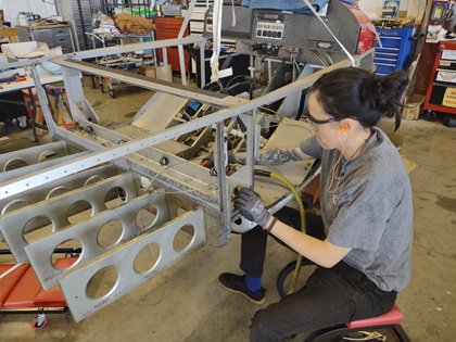 Cassandra Fickel works on a Van’s RV-12 used for training at the Chesapeake Sport Pilot flying school. Photo by Jonathan Welsh.