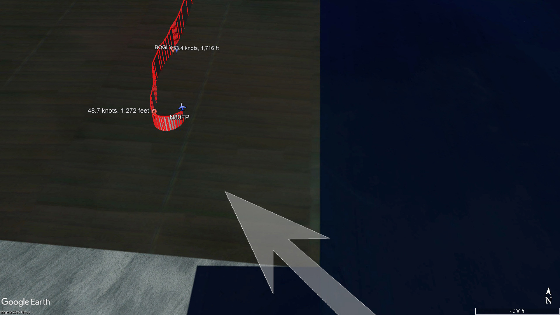 This detail view shows the final ADS-B returns from N80FP, including groundspeed at two of the data points, with reported airport wind (130 degrees, 11 knots) represented by the white arrow. Google Earth image.