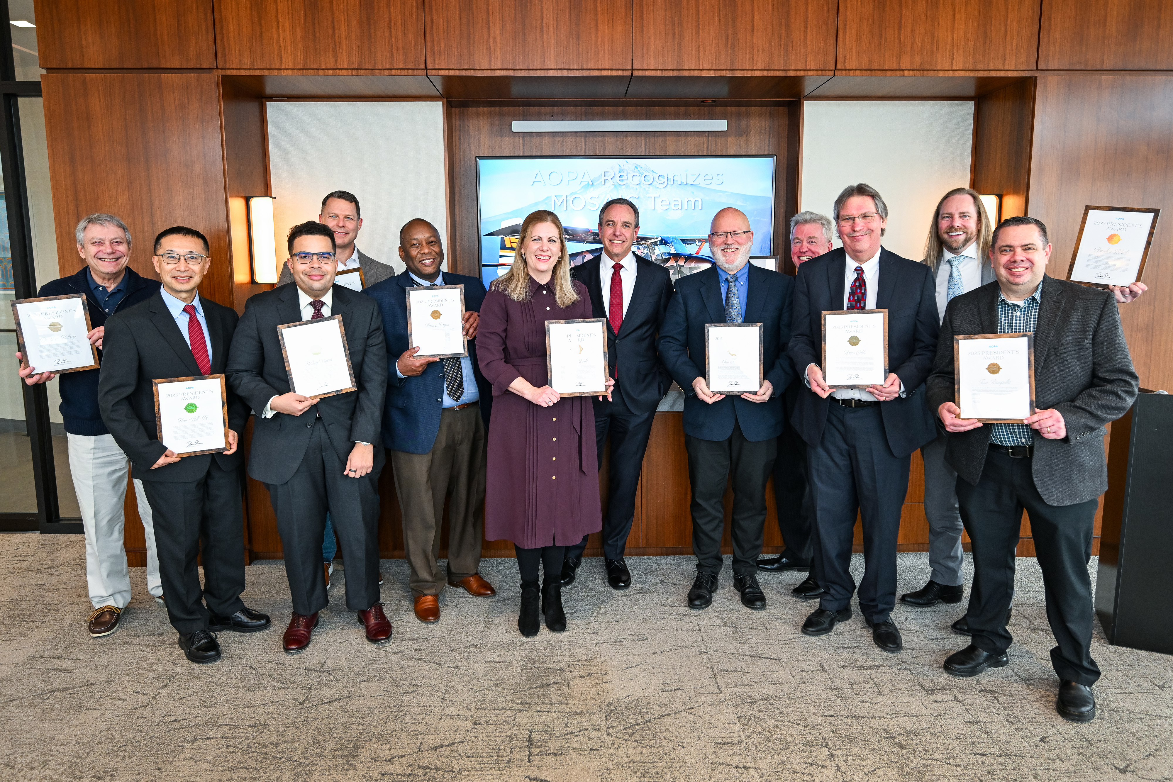 AOPA President Darren Pleasance, center, presents AOPA President's Awards to MOSAIC lead Jim Newberger and other FAA employees on January 6. Photo by David Tulis.